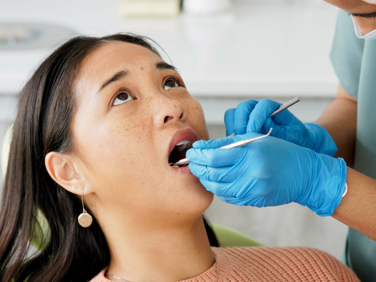 Dentist performing an emergency dental exam for a patient experiencing tooth pain at Dental Care of Cerritos.