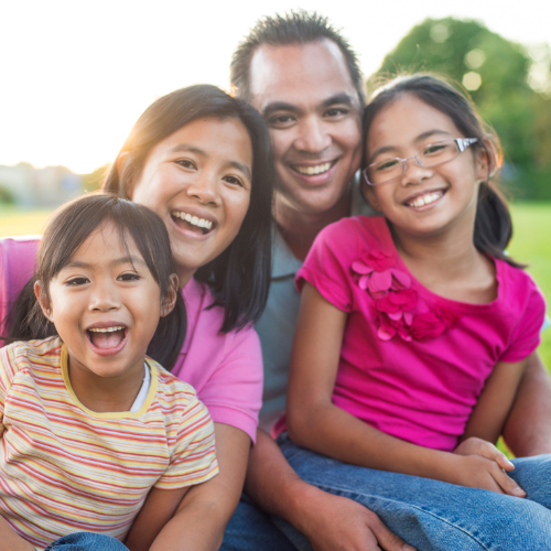 Smiling family representing comprehensive family dentistry for children, adults, and families in Cerritos.