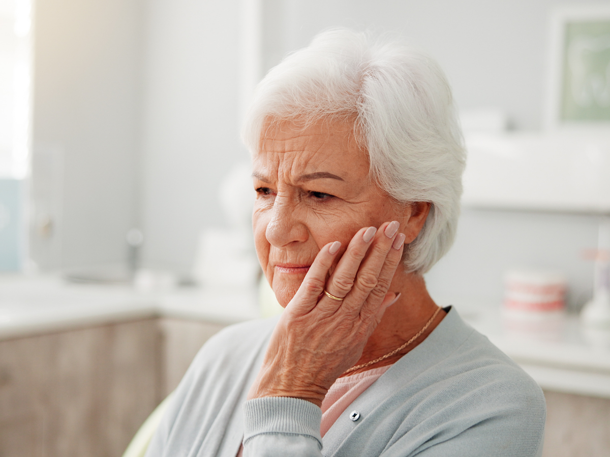 Patient experiencing tooth pain before receiving same-day emergency dental care at Dental Care of Cerritos.