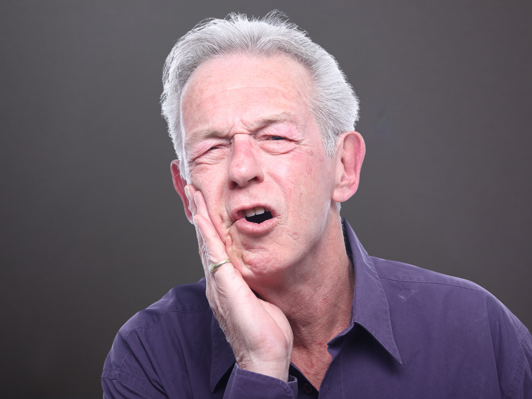 Patient with dental discomfort representing tooth extractions and specialty dental care in Cerritos.