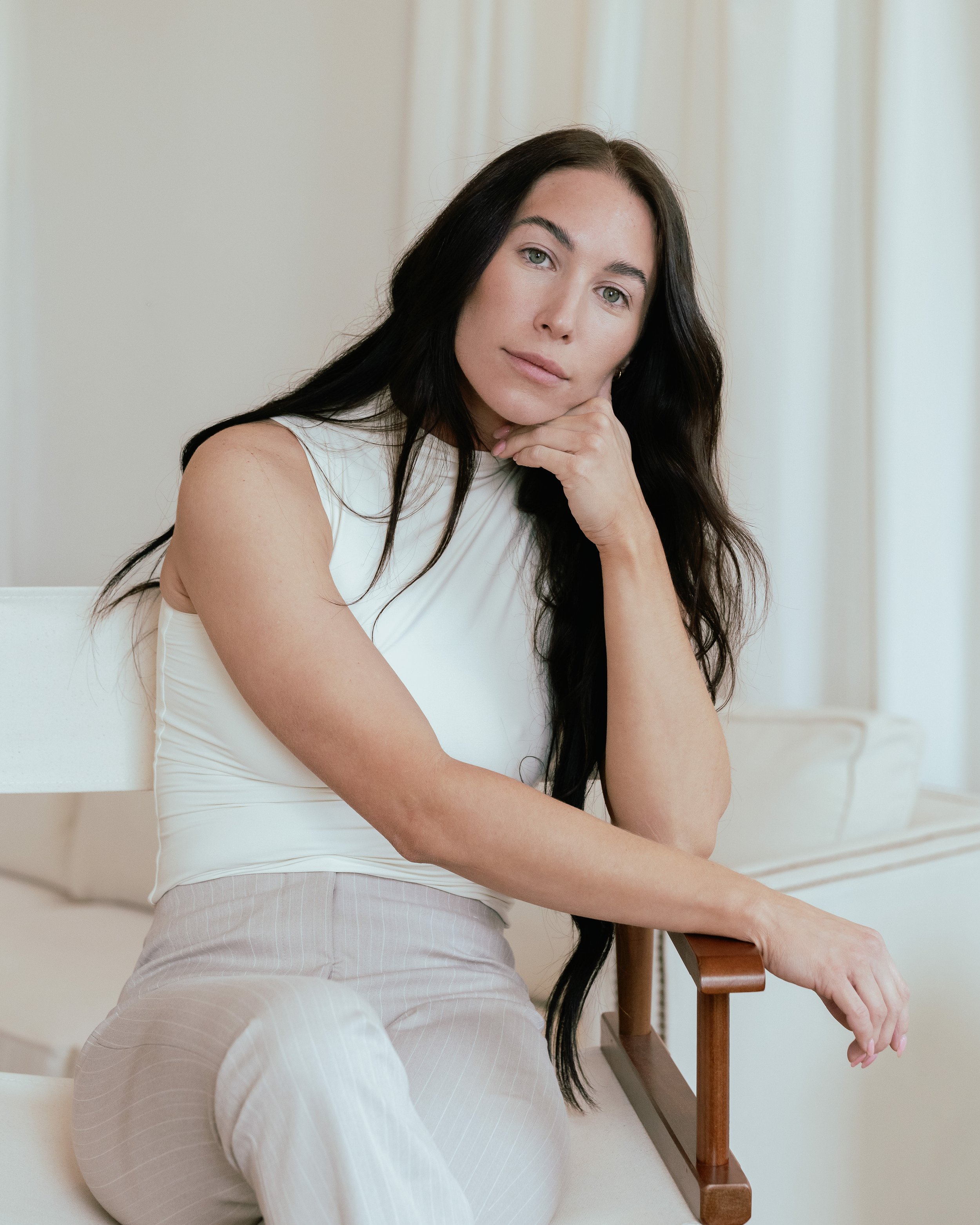 Gabriella Castellani, MS, OTR/L, sitting in soft natural light, reflecting on her personal endometriosis diagnosis story and her work as a women's health advocate.