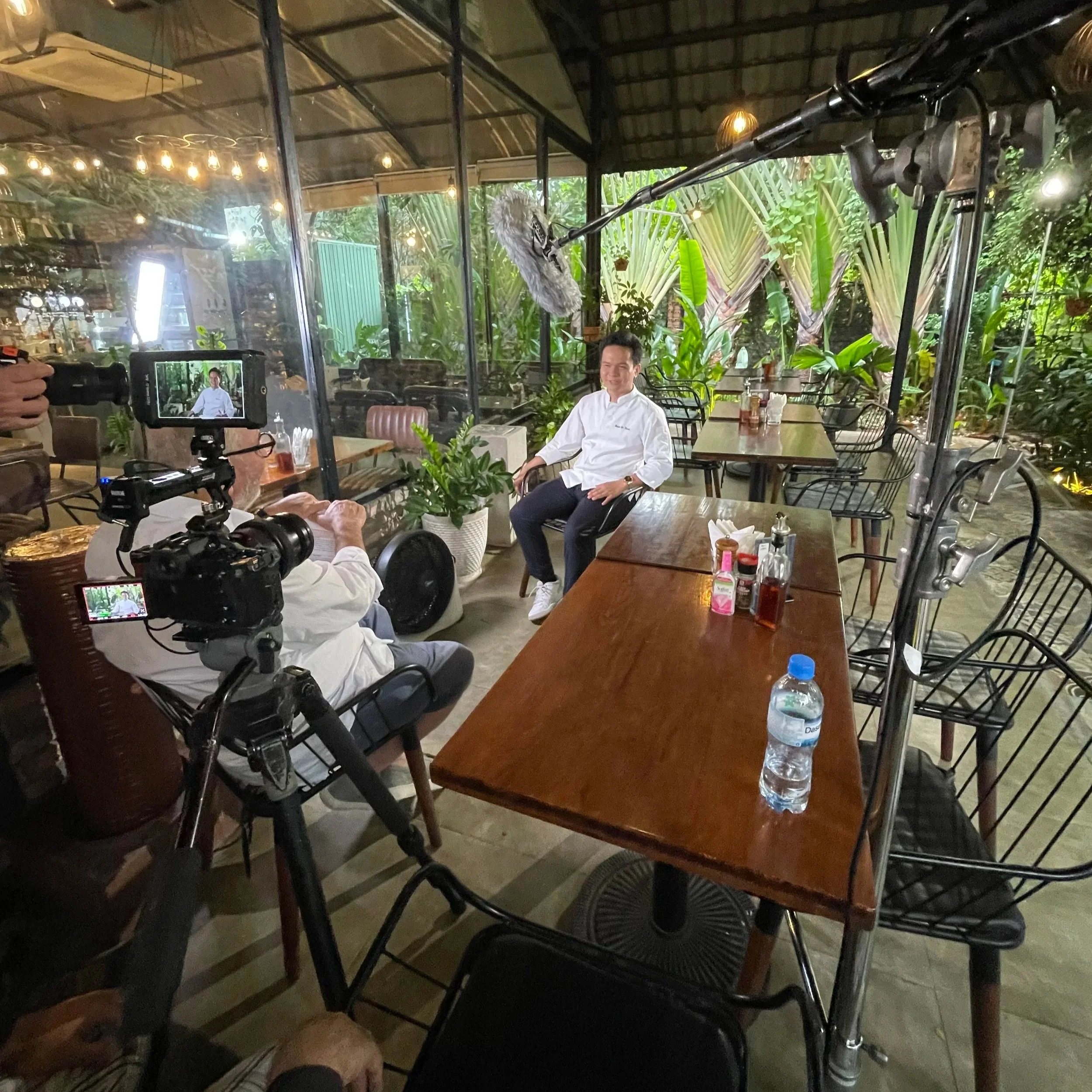 On-location sit-down interview frame from 'Spaghetti Conquest' in Vietnam. Creating a controlled, cinematic interview space within an authentic, bustling local eatery.
