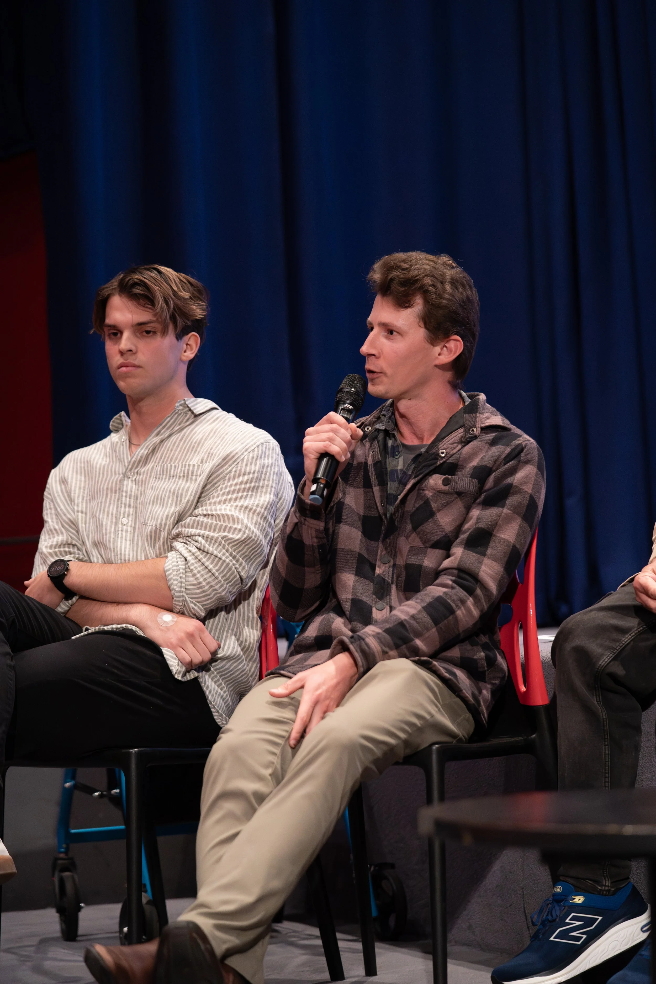 Alistair Schmidt speaking at a Q&A panel for his film Chloe's Palette at the 2025 Adelaide Independent Film Festival. Professional filmmaker discussing indie movie production and directing, captured live on stage with a microphone.
