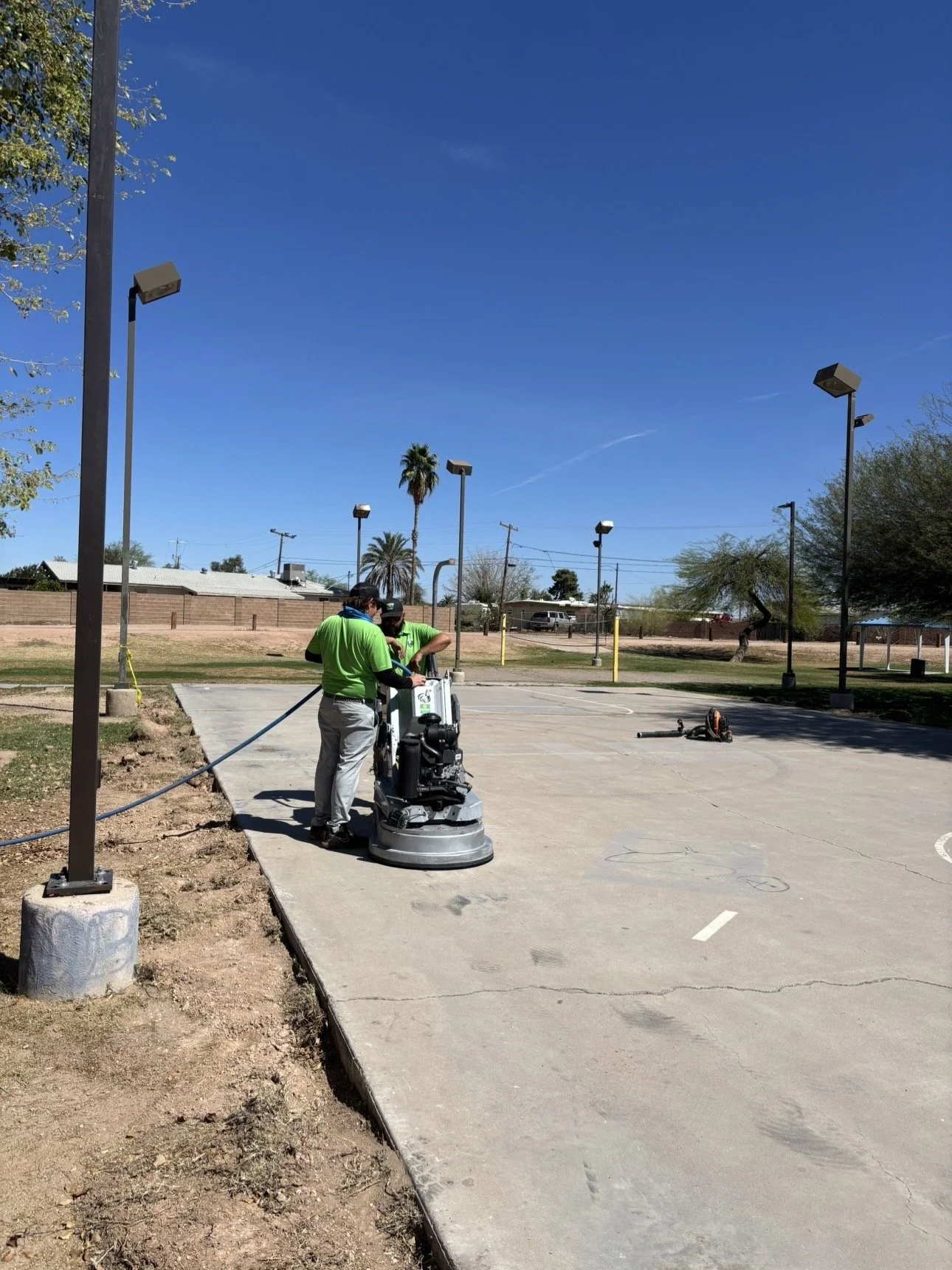 True Hop Field Co, Arizona sports field & court construction, team members working on basketball court resurfacing and striping.