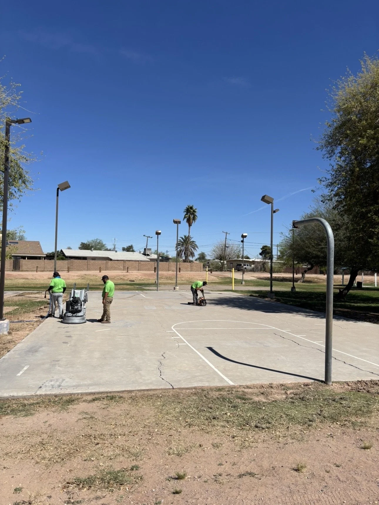 True Hop Field Co, Arizona sports field & court construction, team members working on basketball court resurfacing and striping.