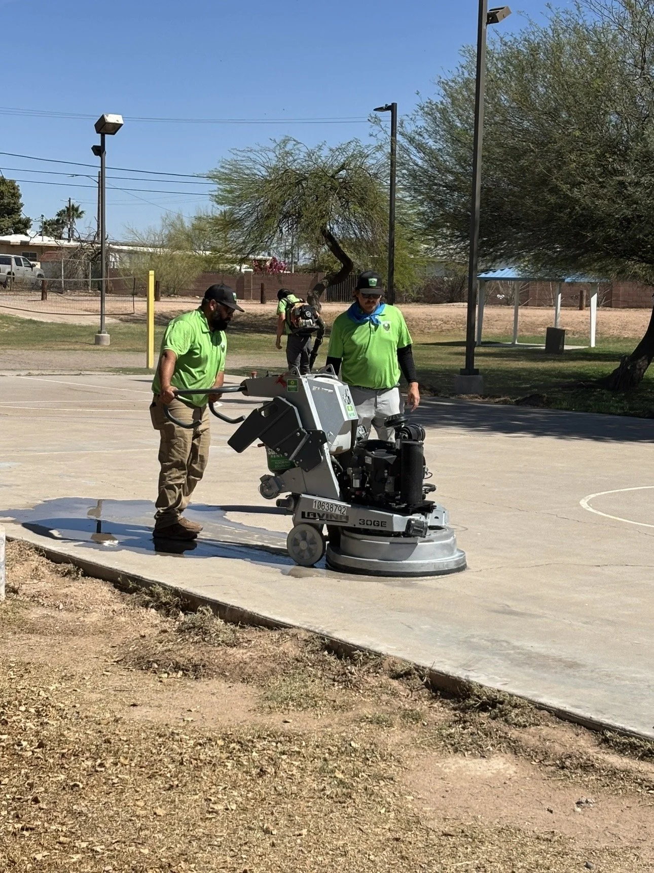 True Hop Field Co, Arizona sports field & court construction, team members working on basketball court resurfacing and striping.