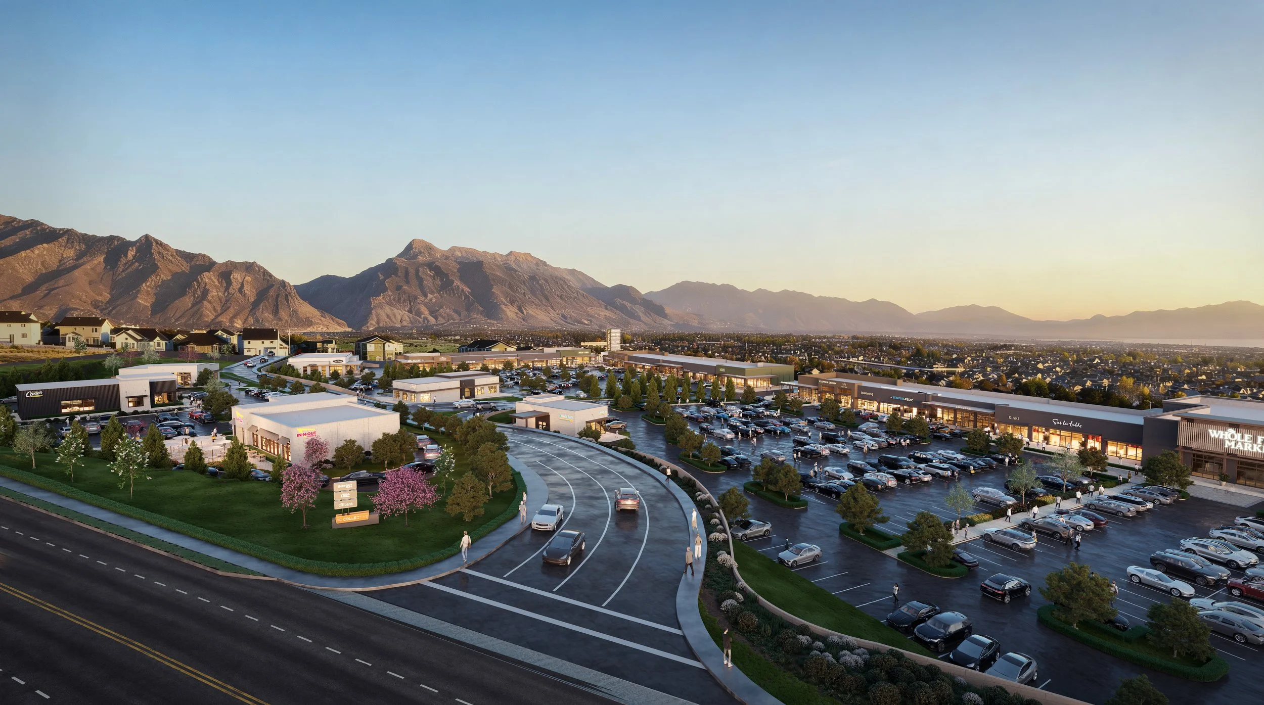 The Collective at Morning Vista shopping center parking lot at sunset with mountains in the background, surrounded by trees and flowers.