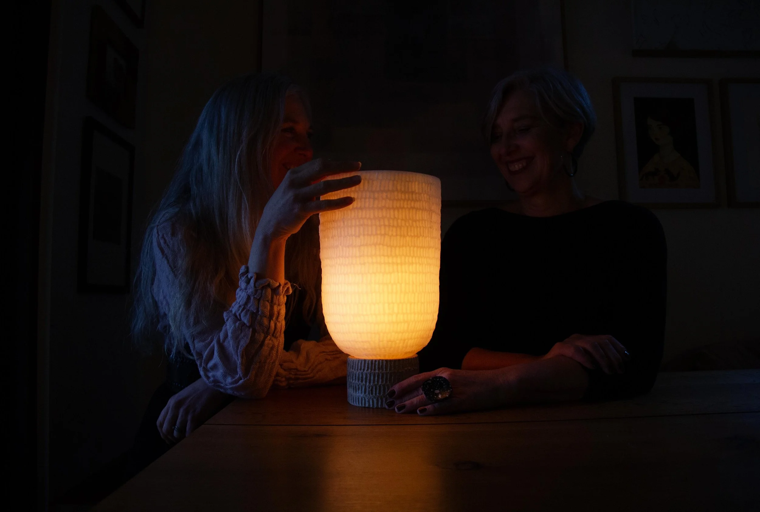 softly glowing kindred wax lantern with friends laughing by it