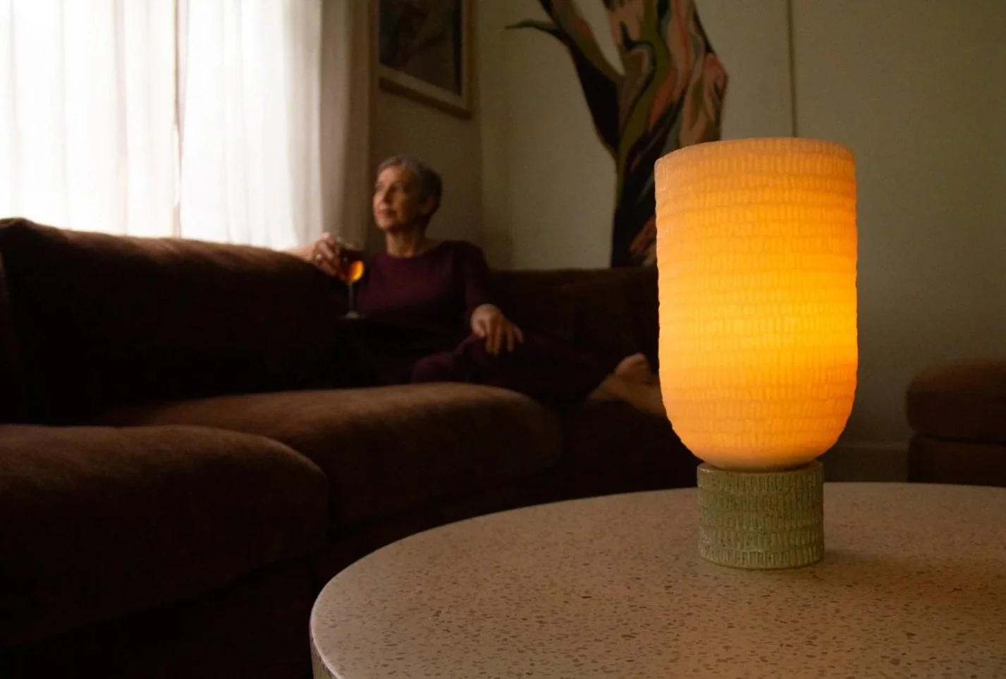 pensive person contemplating near soft glow of Kindred wax lantern
