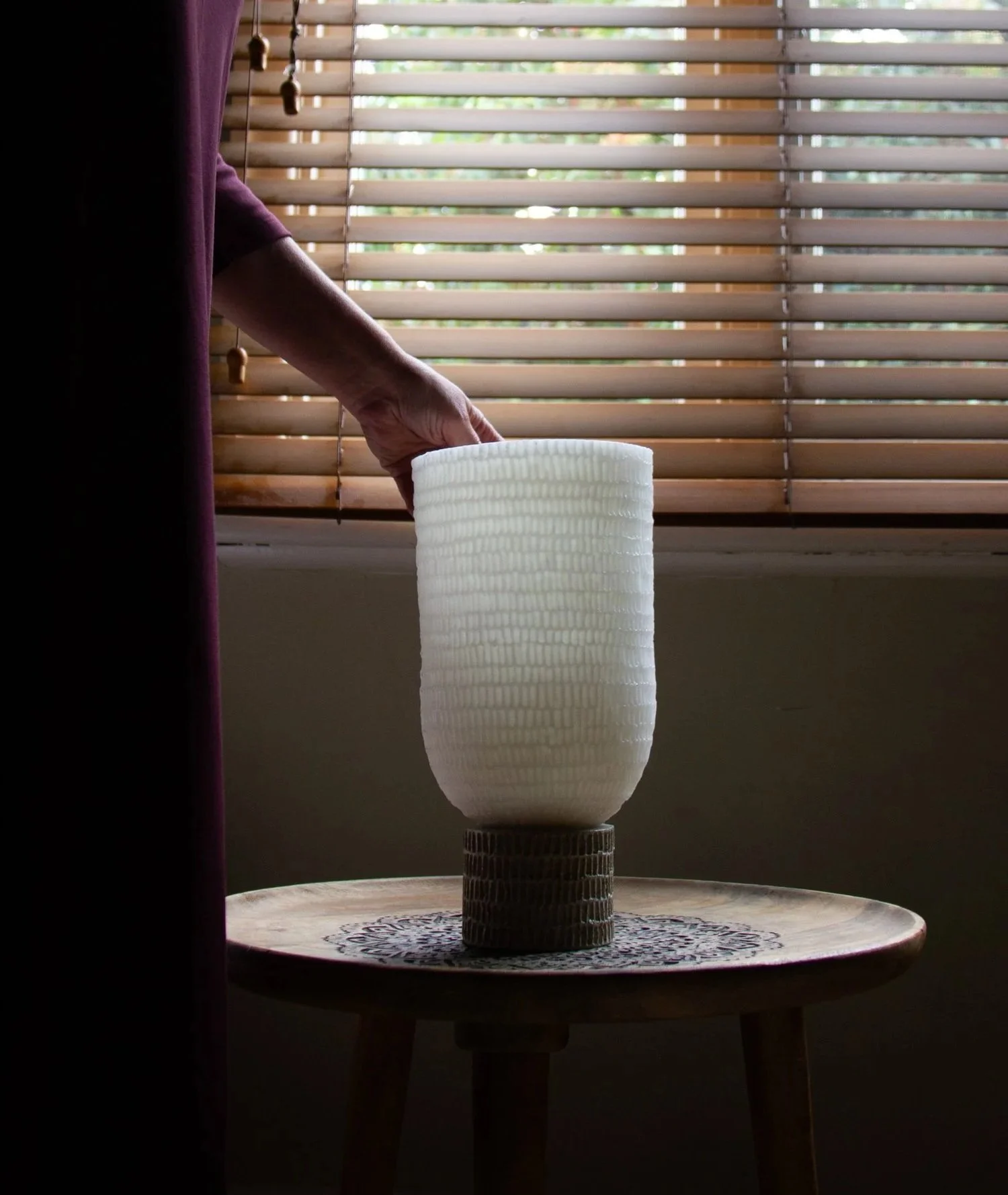 quiet image of unlit wax candle in afternoon light