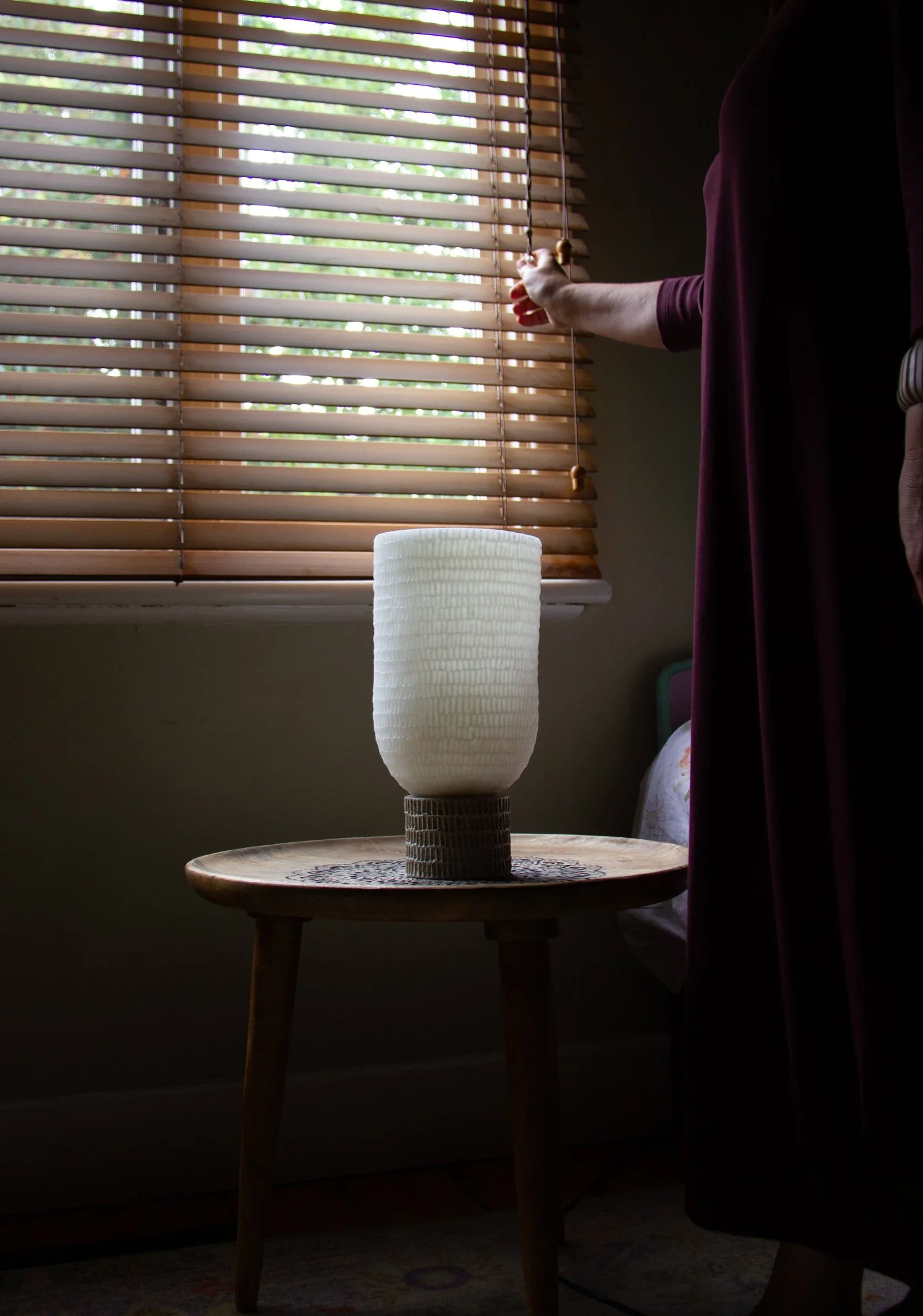 Kindred lantern in afternoon light on carved table top