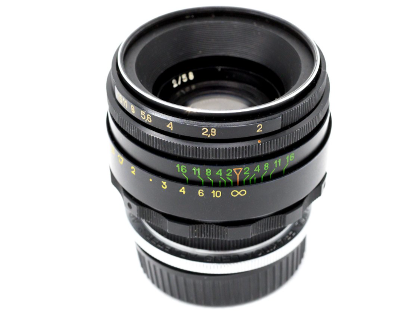 Close-up of a vintage camera lens with aperture and focus distance markings.