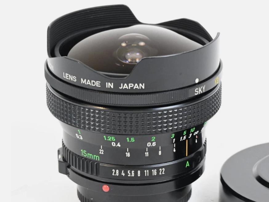 Close-up of a camera lens with markings indicating focus and aperture, labeled 'Lens Made in Japan' and 'Sky YS 15mm f/2.8'.