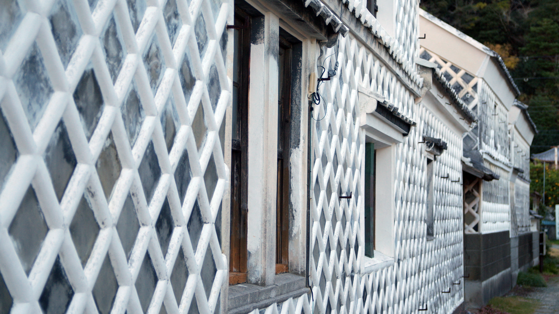 Exterior of a building with a white lattice wall in Japan.