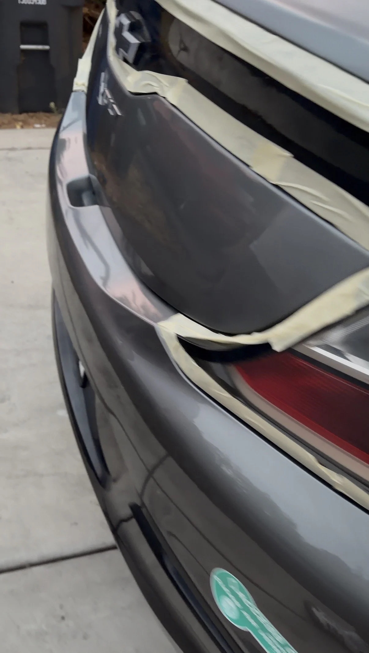 Close-up of a car's rear bumper and trunk edge during a detail