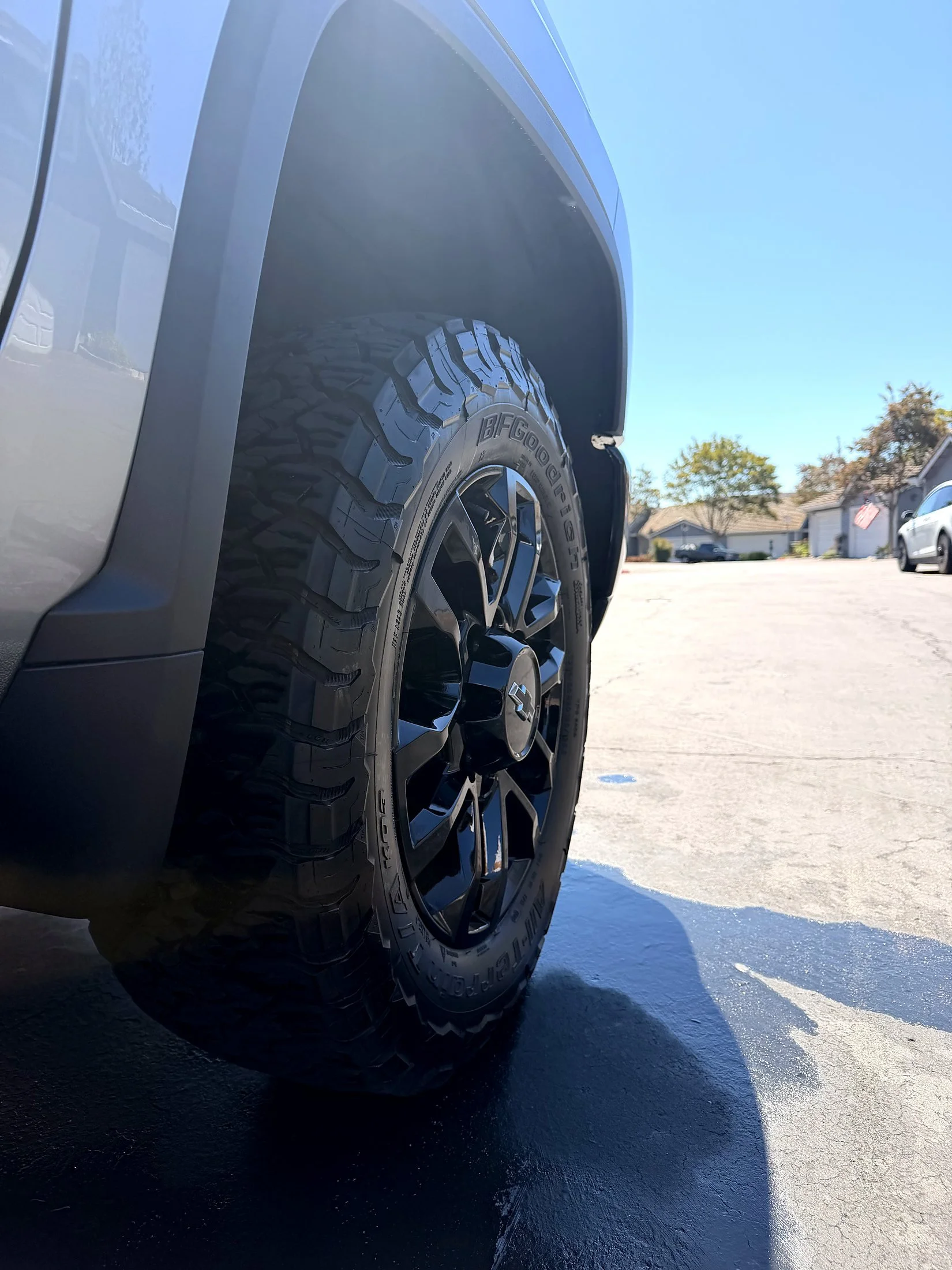 Black wheel and all-terrain tire on a Chevy Silverado HD after a wheel cleaning