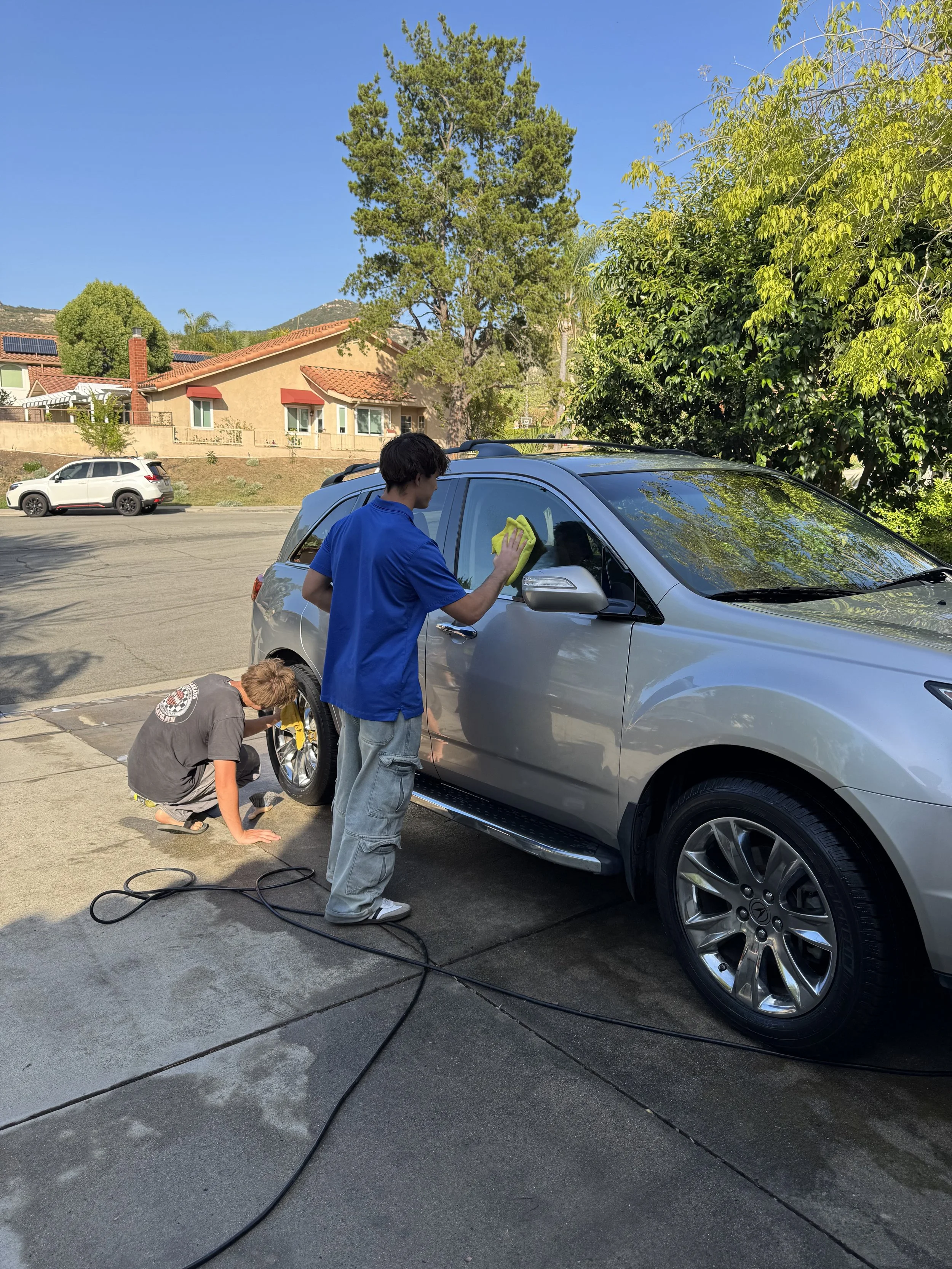 Gabriel Santo, founder of Santo's Suds mobile car detailing, working on a vehicle in Poway, California