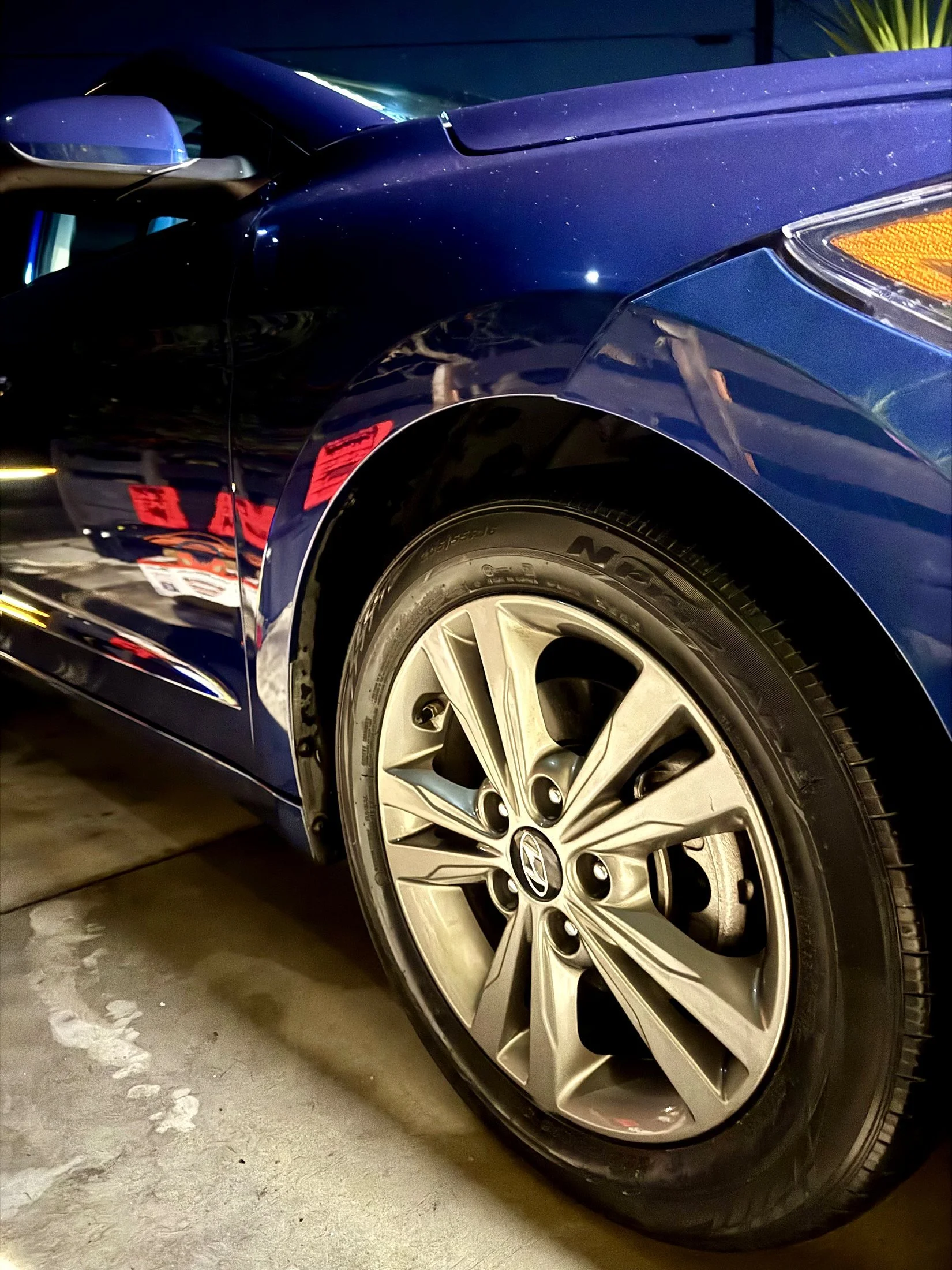 Blue sedan with glossy paint and a cleaned silver alloy wheel