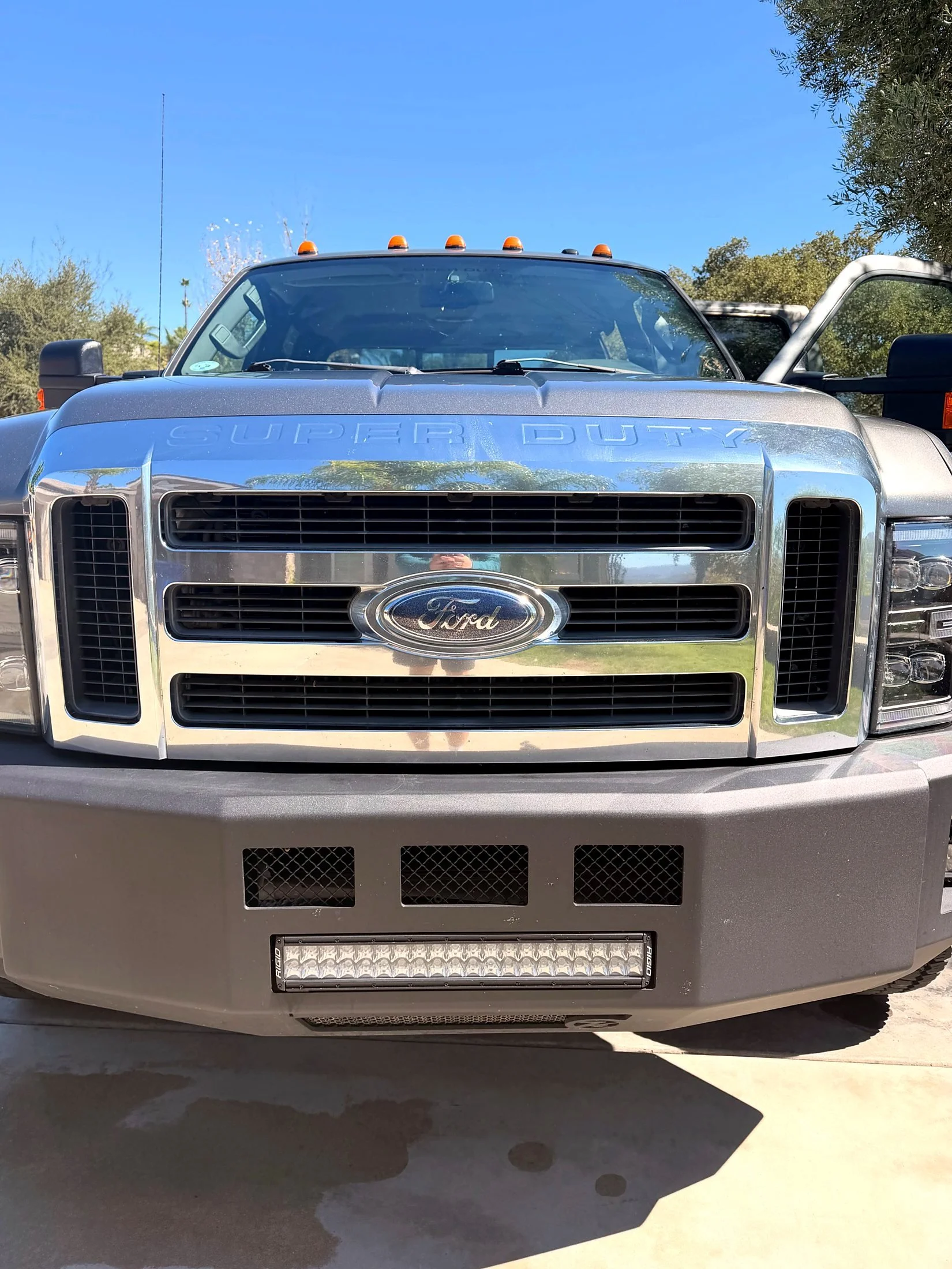 Silver Ford Super Duty truck with chrome grille after an exterior wash