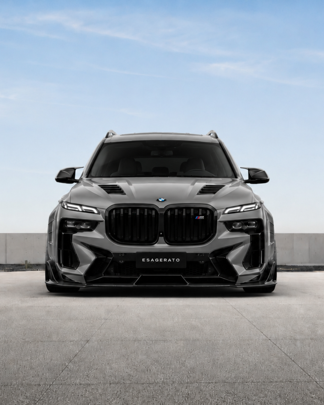 Front view of a black BMW X7 Esagerato SUV parked outdoors under a blue sky with some clouds.
