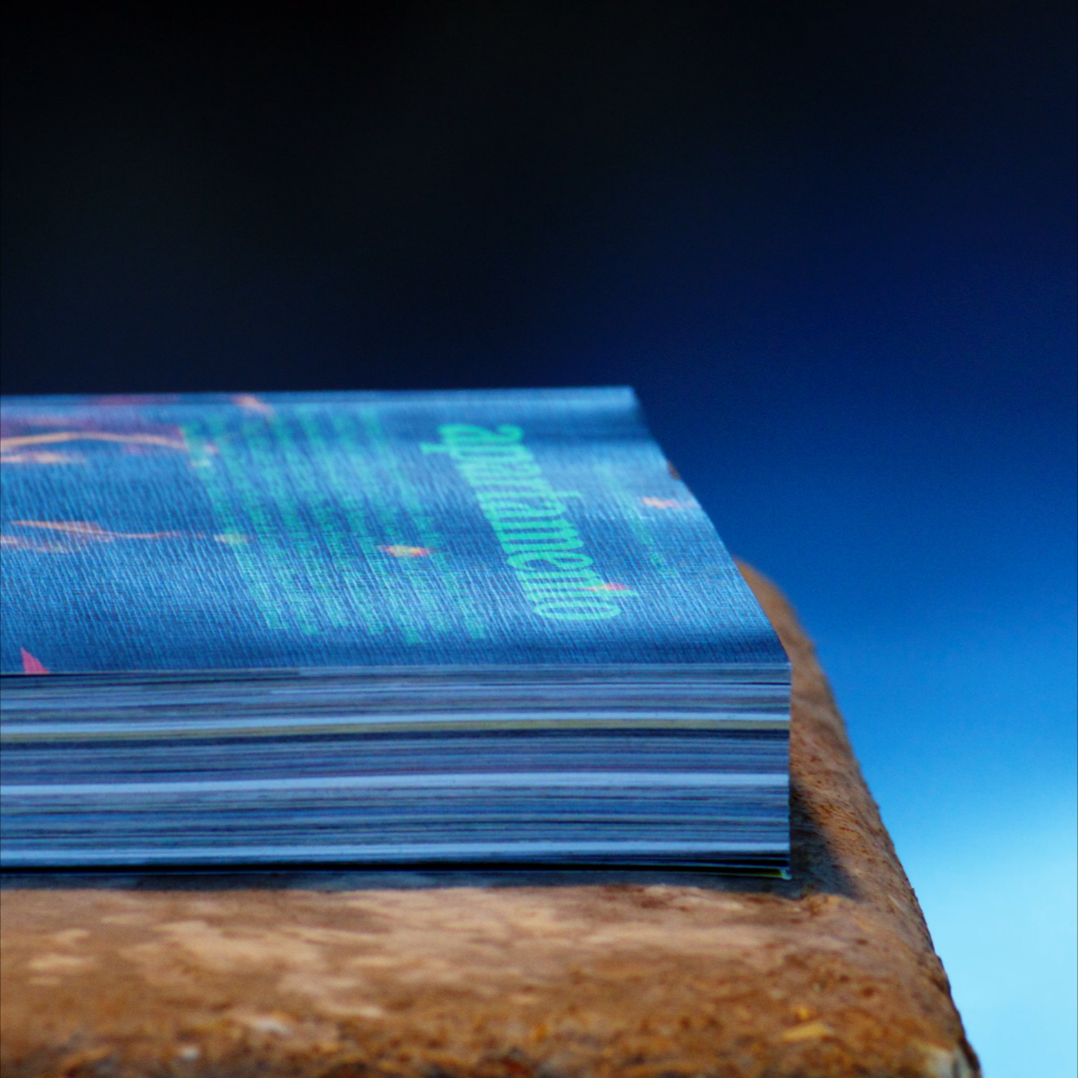 Close-up of a stack of credit cards on a wooden surface with a blue background
