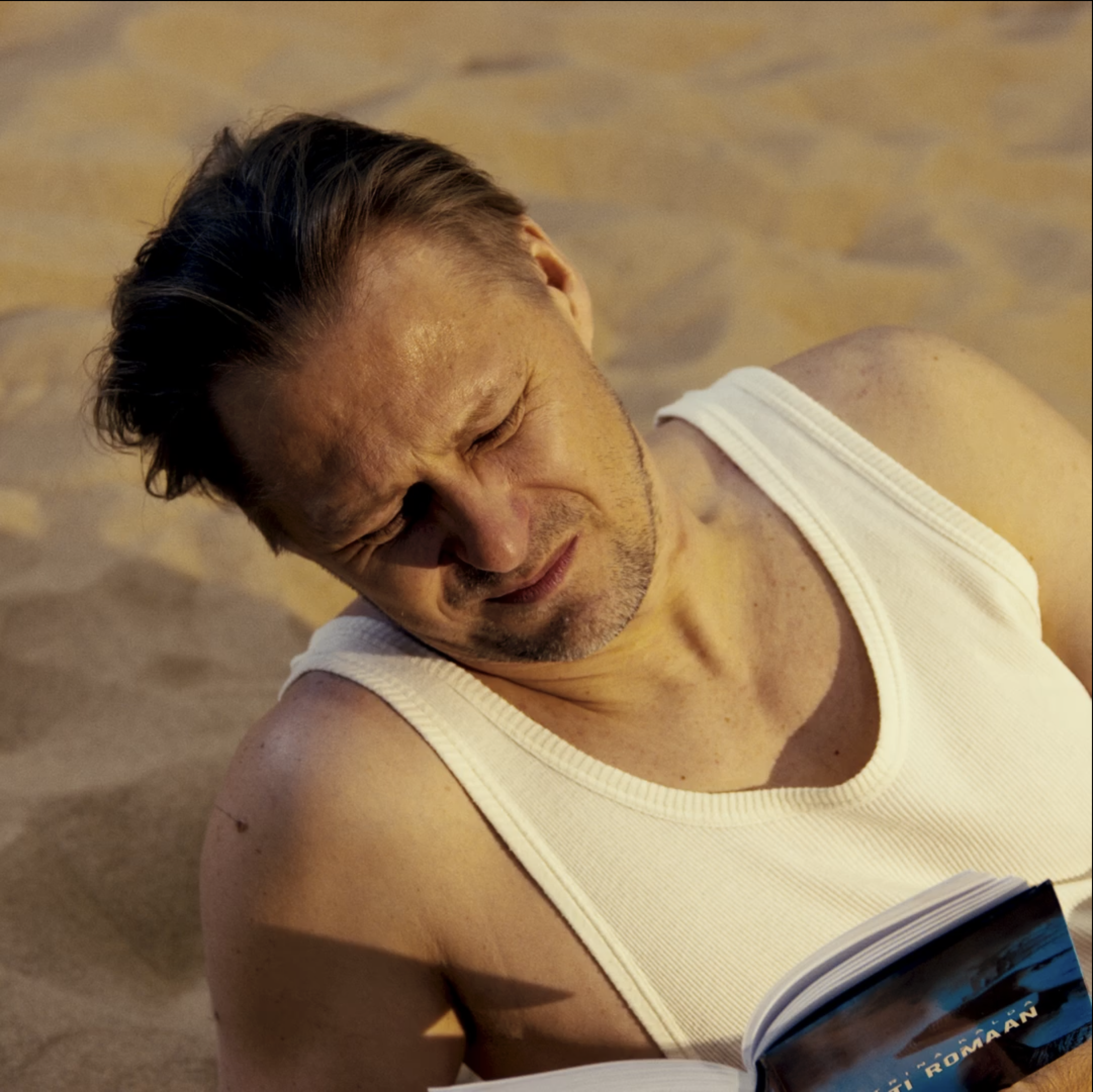 Close-up of a person's face with closed eyes, lying on the floor, indicating they might be resting or sleeping.