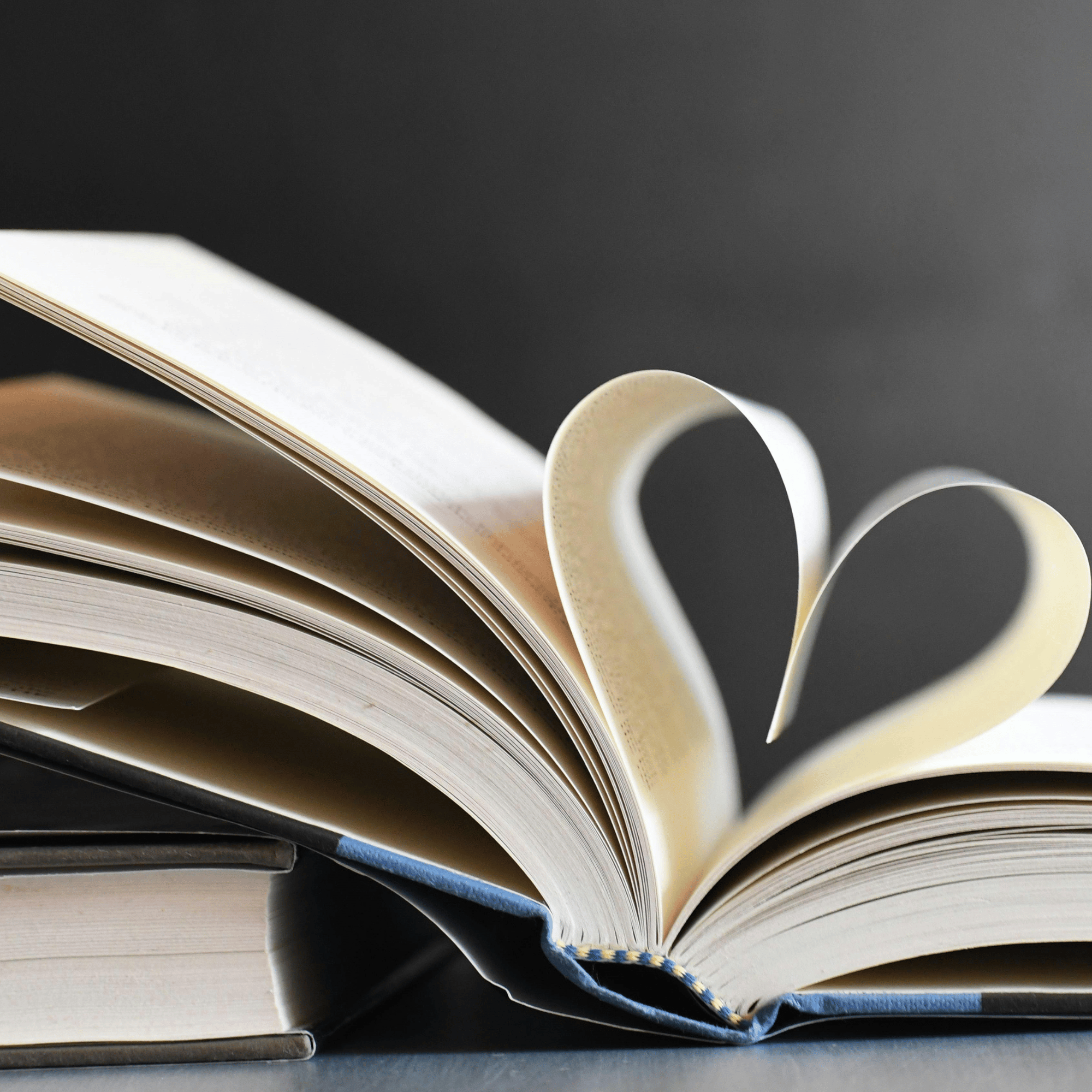 Un livre ouvert avec deux pages pliées en forme de cœur.