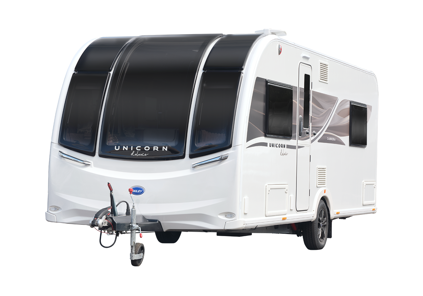 White travel trailer with black tinted windows, labeled 'Unicorn deluxe', attached to a vehicle, on a black background.