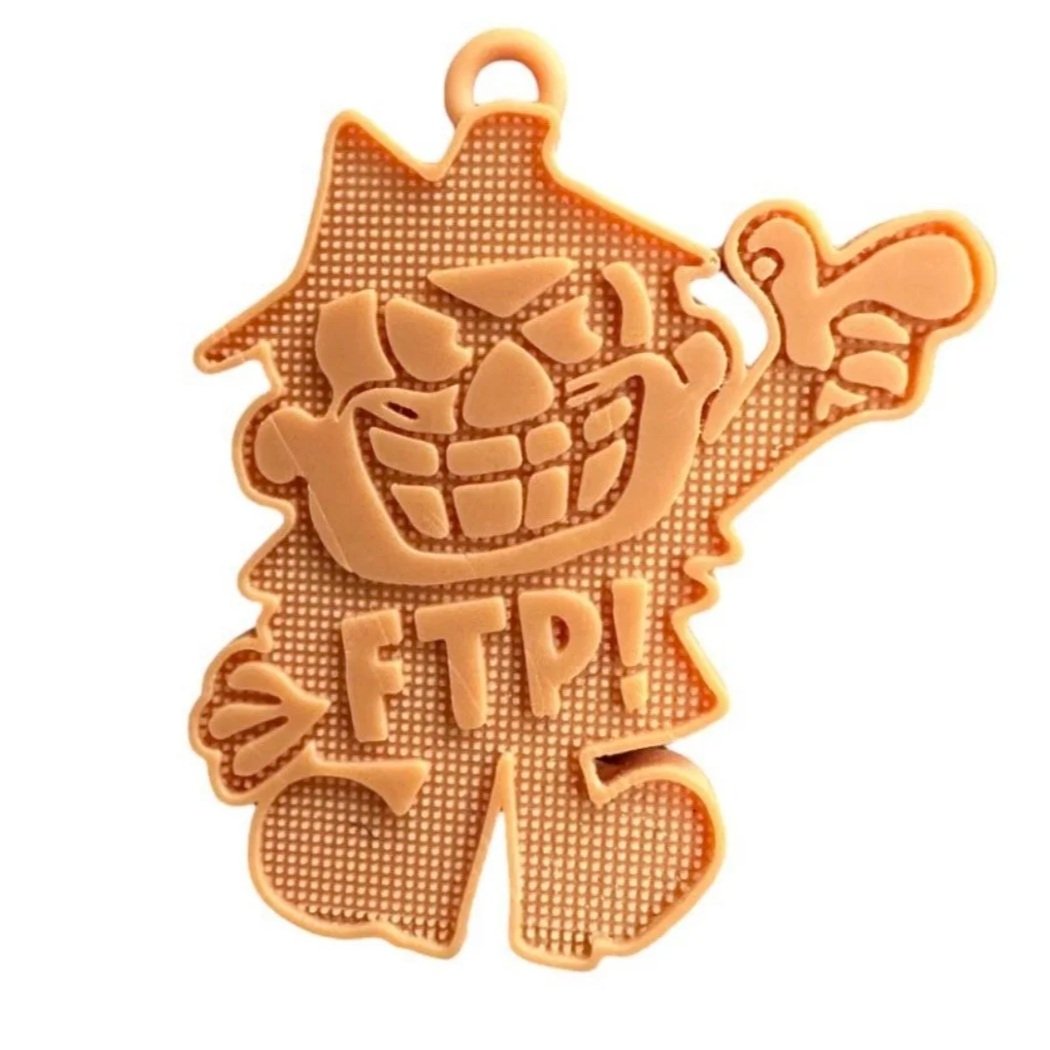 A Halloween-themed cookie cutter with a smiling pumpkin face, a witch's hat, and the letters 'FTP!' on it.