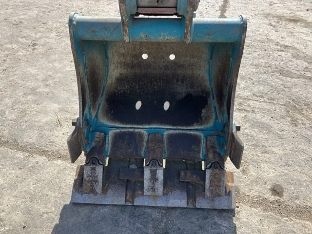 Close-up of a bulldozer's rubber track and undercarriage, showing dirt and wear.