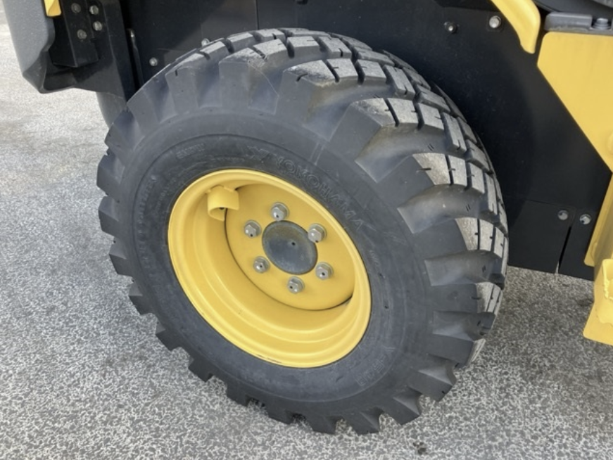 Close-up of a large yellow tire on a construction vehicle, showing the tread and wheel.