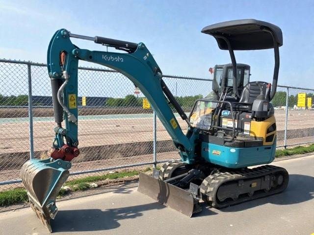 Close-up view of a yellow construction equipment engine with various hoses, filters, and components visible.