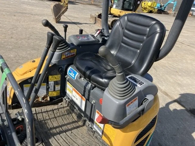 Close-up of a tracked construction vehicle's undercarriage, showing a large rubber track, sprocket, and hydraulic components.