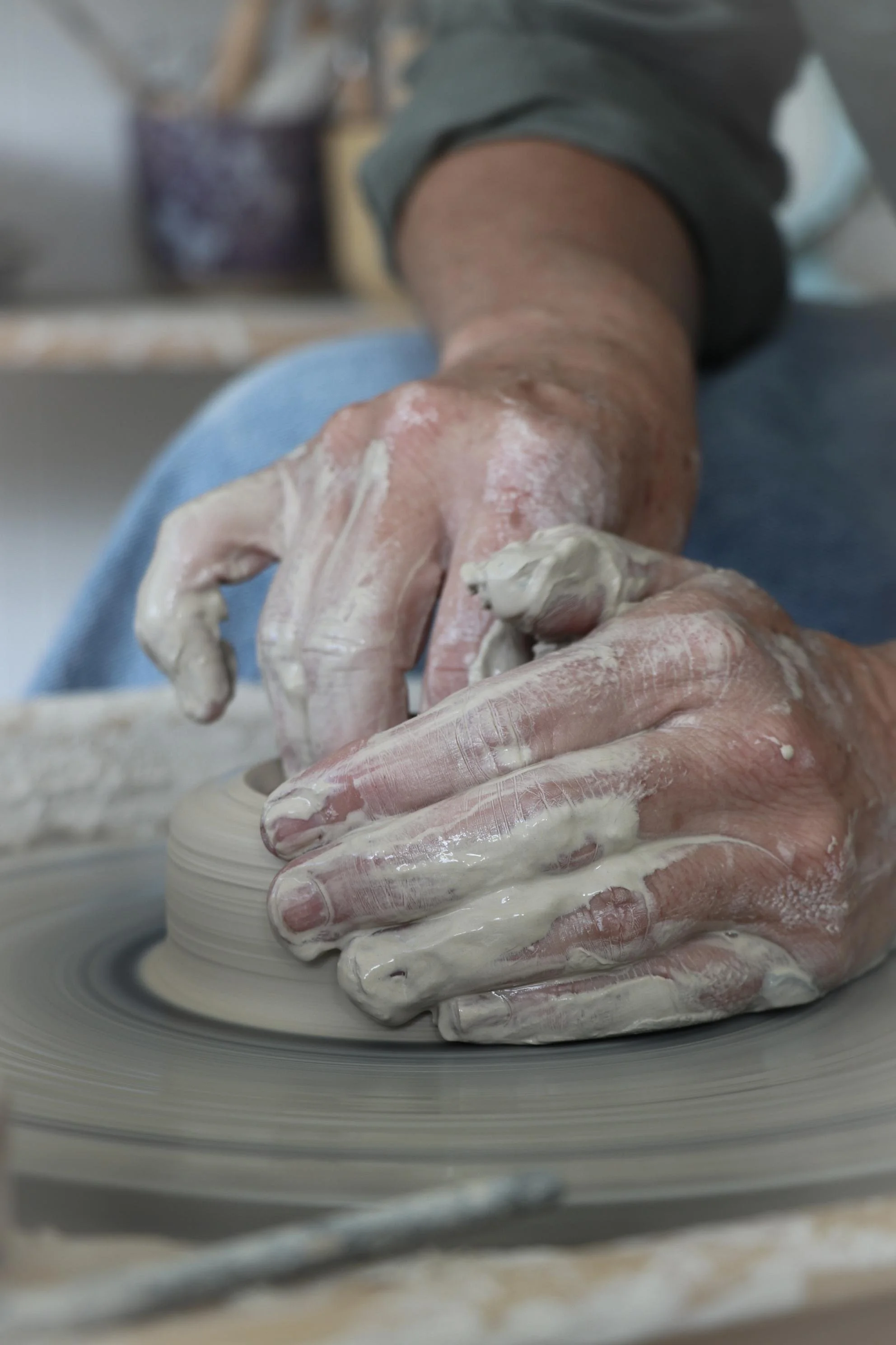 Close-up of hands shaping clay on a pottery wheel.