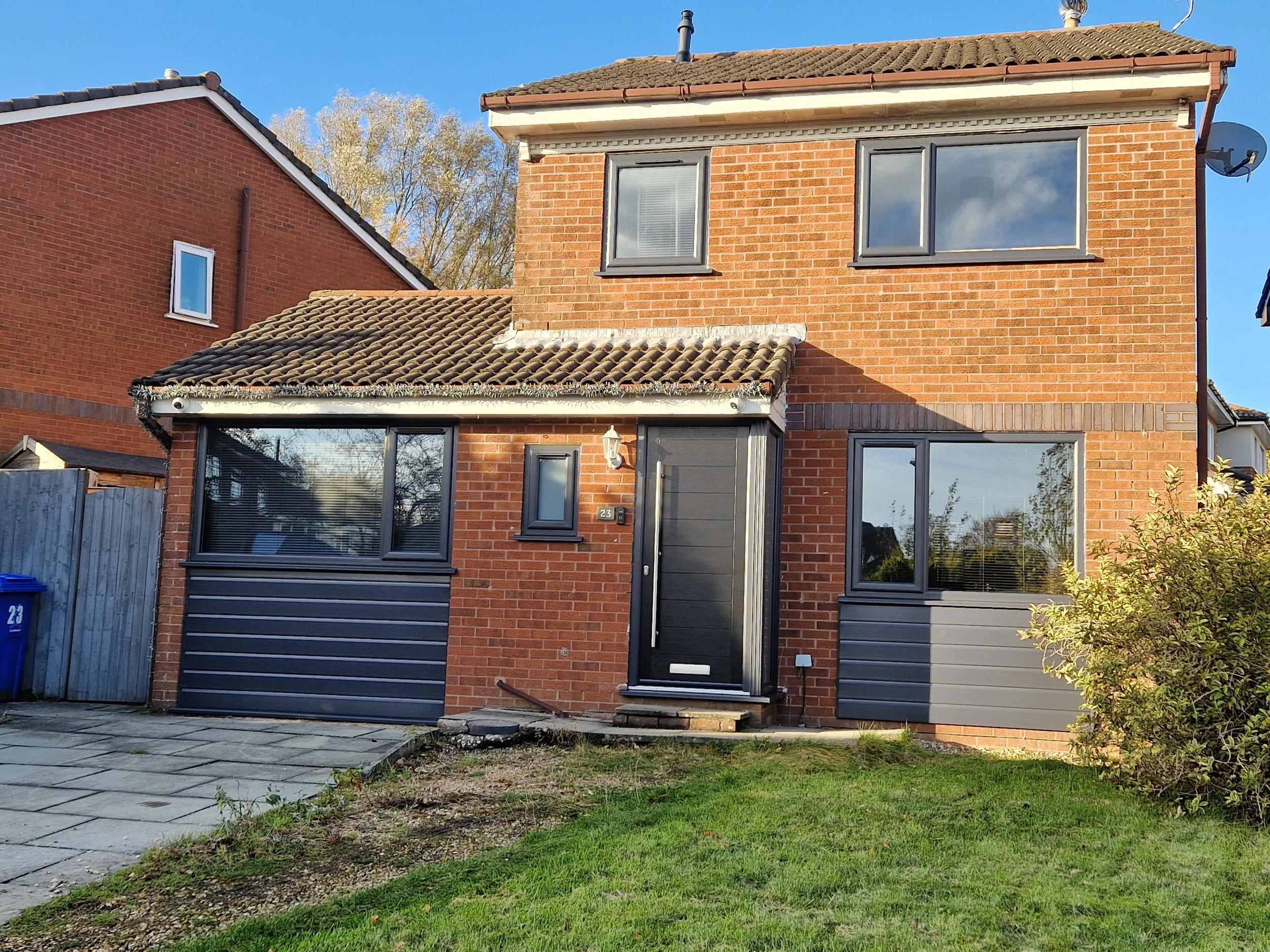Full Anthracite Grey exterior transformation, featuring replacement PVC windows, matching composite front door, and premium cladding beneath the ground-floor windows.