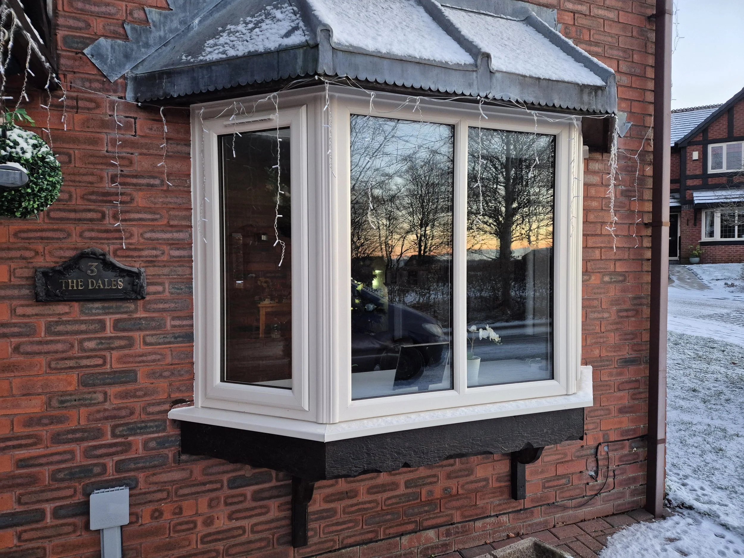 Classic crisp white PVC bay window replacement. This multi-facet upgrade replaces dated frames with high-performance, energy-efficient glazing, flooding the interior with natural light while retaining the home's traditional architectural character.