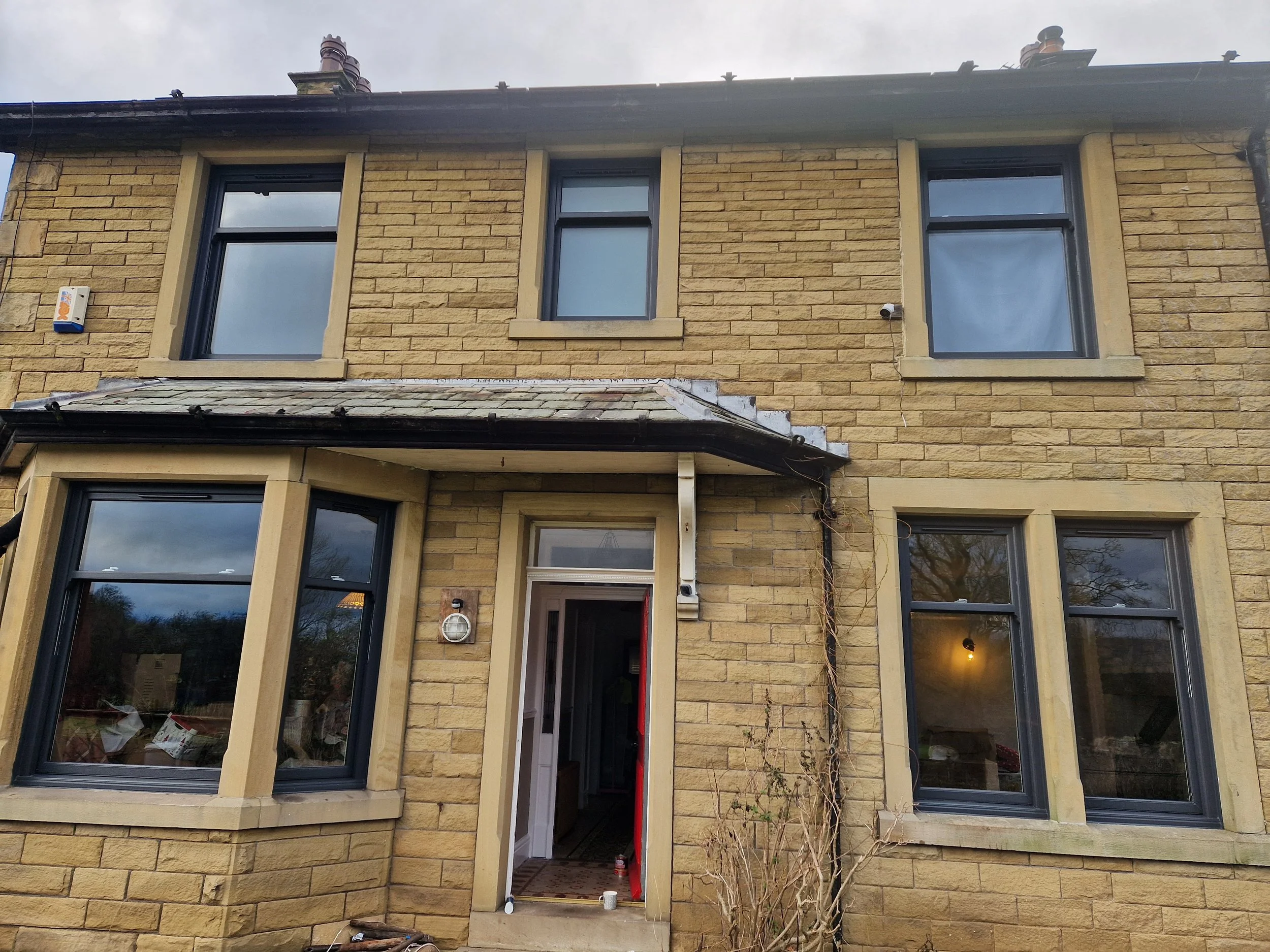 Anthracite Grey PVC sliding sash windows transformation ... all front exterior windows replaced with a modern dark profile on a classic heritage design. These vertical sliders seamlessly combine traditional architectural charm on a period property.