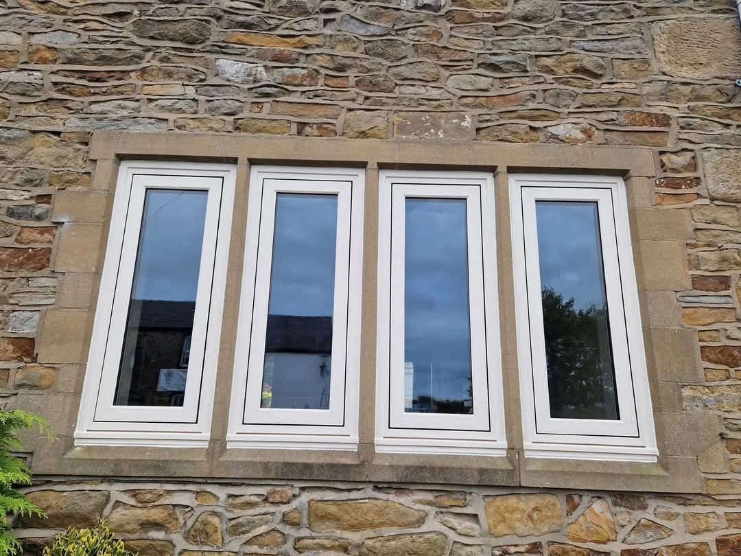 Set of four agate grey PVC flush-fit windows installed on a charming character cottage. The sleek, flat-profile frames perfectly balance modern architectural styling with traditional period charm.