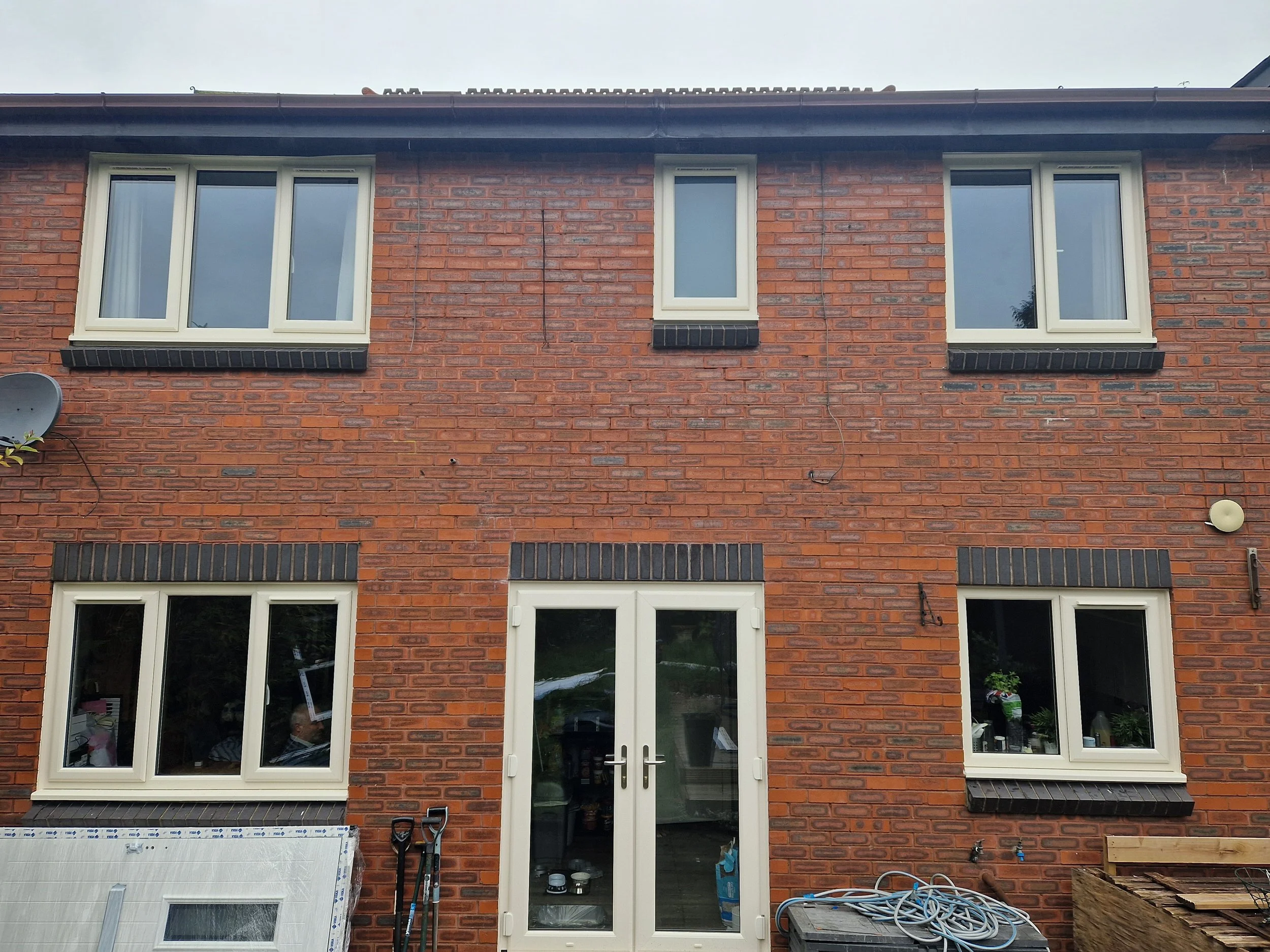Full rear property transformation featuring premium cream PVC windows and matching PVC French doors opening directly into the back garden.