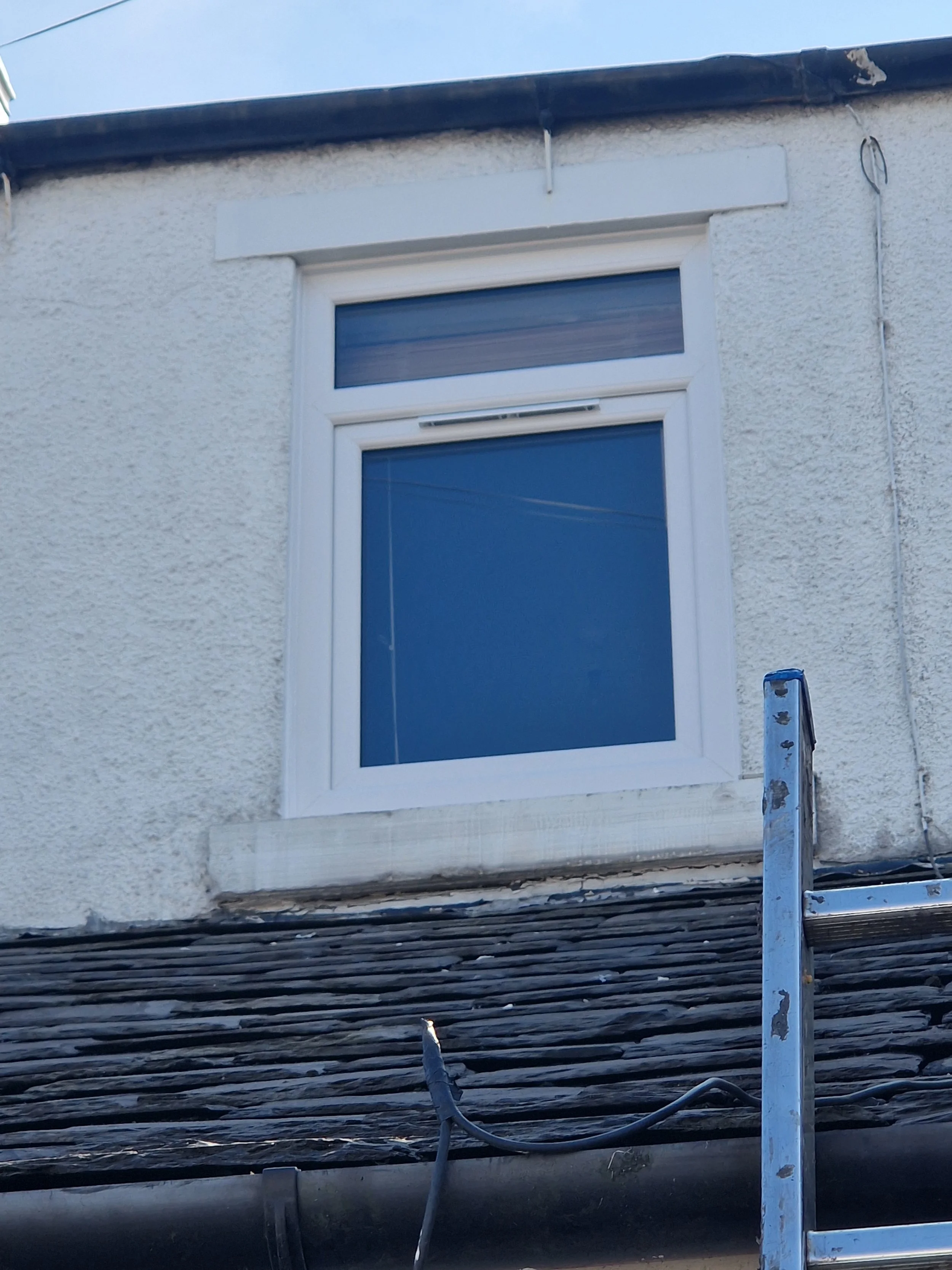 White PVC window fitted to a first floor of a property, with tilt-and-turn opening.