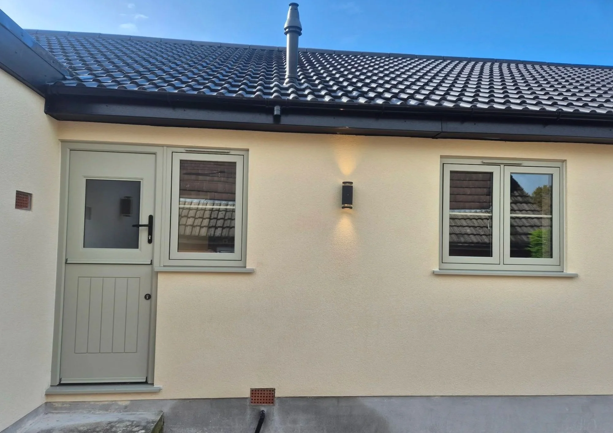 Secure stable Rockdoor installed at the back of a residential property in Langho, finished in Pebble Grey. uPVC windows in Pebble Grey with astrigal bars.