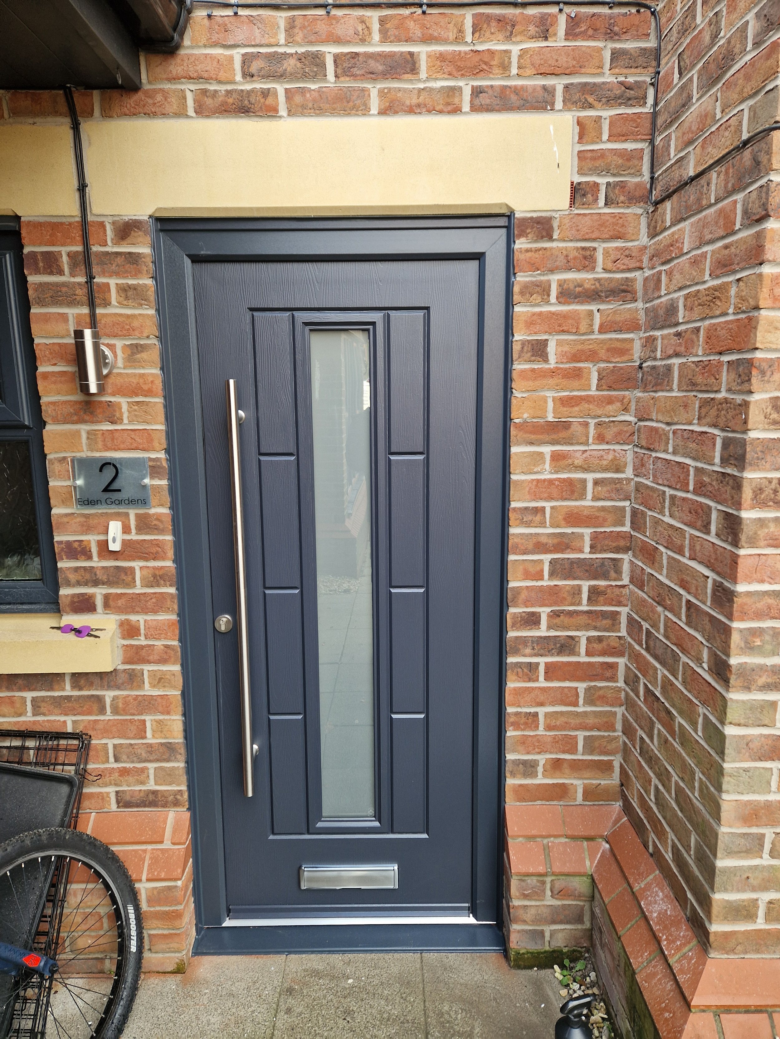 Modern anthracite grey Rockdoor, with satin glass center panel and matching grey frame. 
