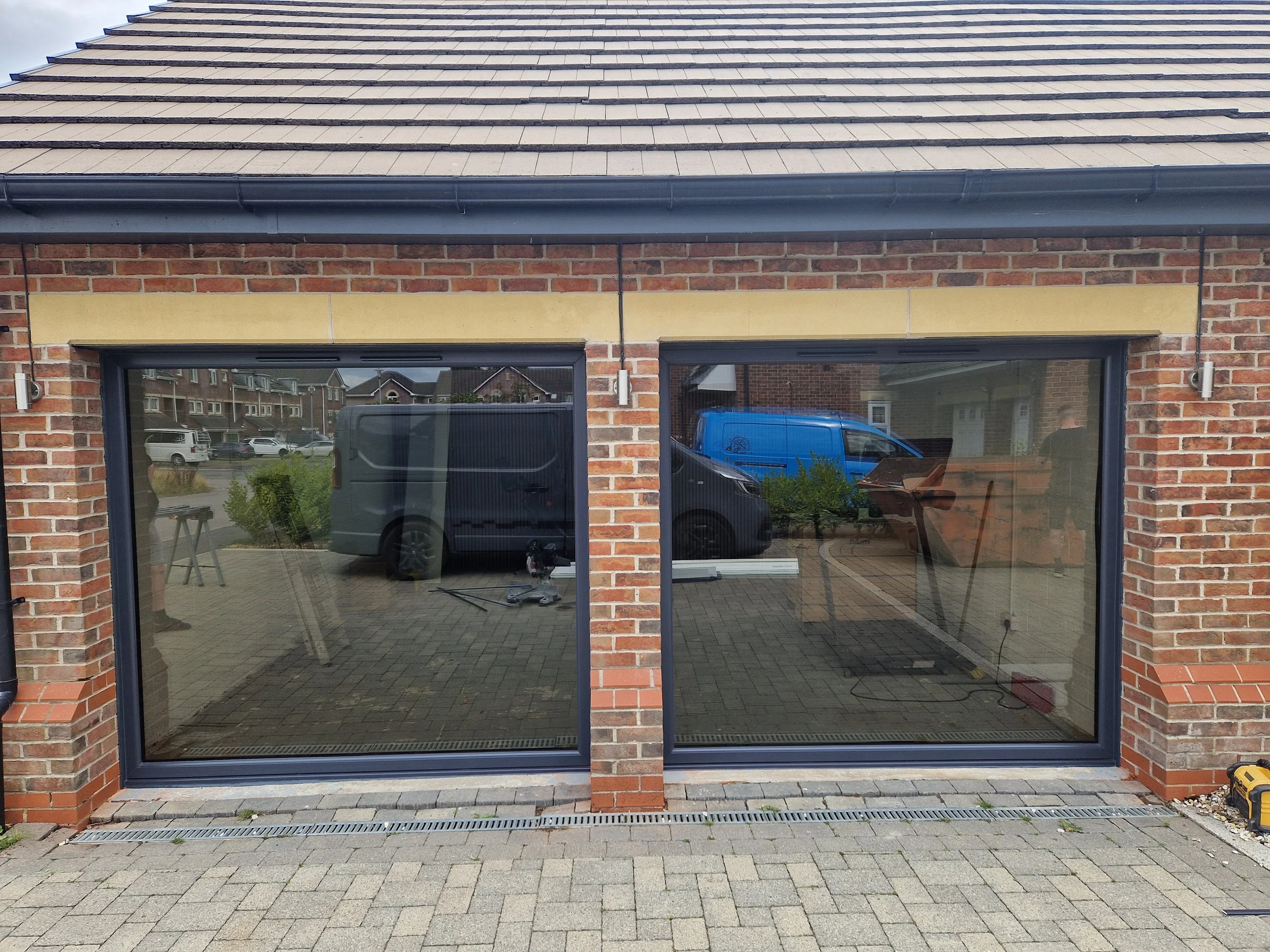 Anthracite Grey PVC fixed windows featuring premium tinted glass, installed to replace double garage doors for a home gym conversion. These sleek architectural panels maximise natural daylight and privacy for workouts while completely modernising the