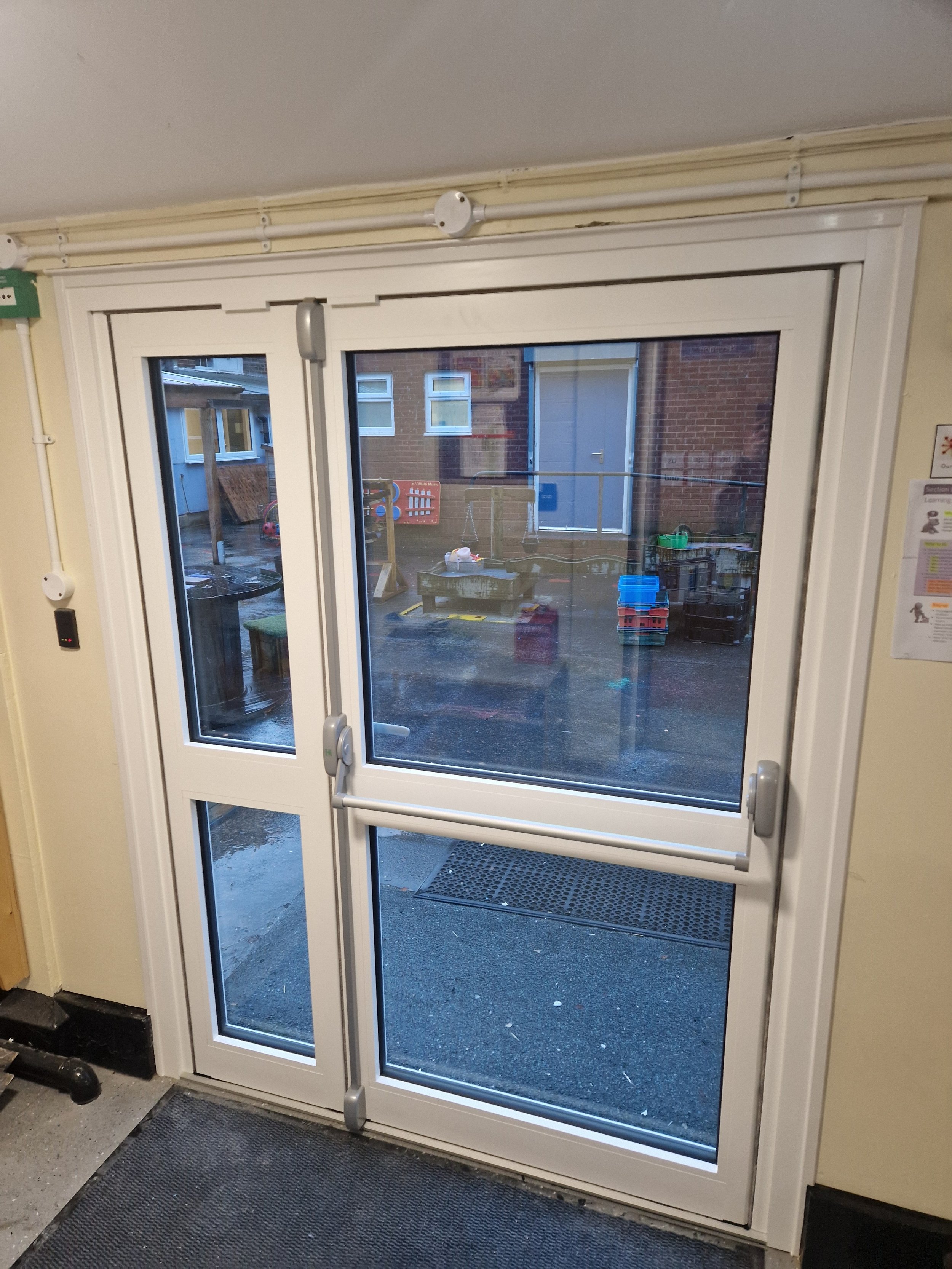 Commercial aluminium door precision-fitted for a school building upgrade. Engineered for high-traffic educational environments, this professional installation features a heavy-duty panic bar mechanism to ensure building compliance and maximum safety.