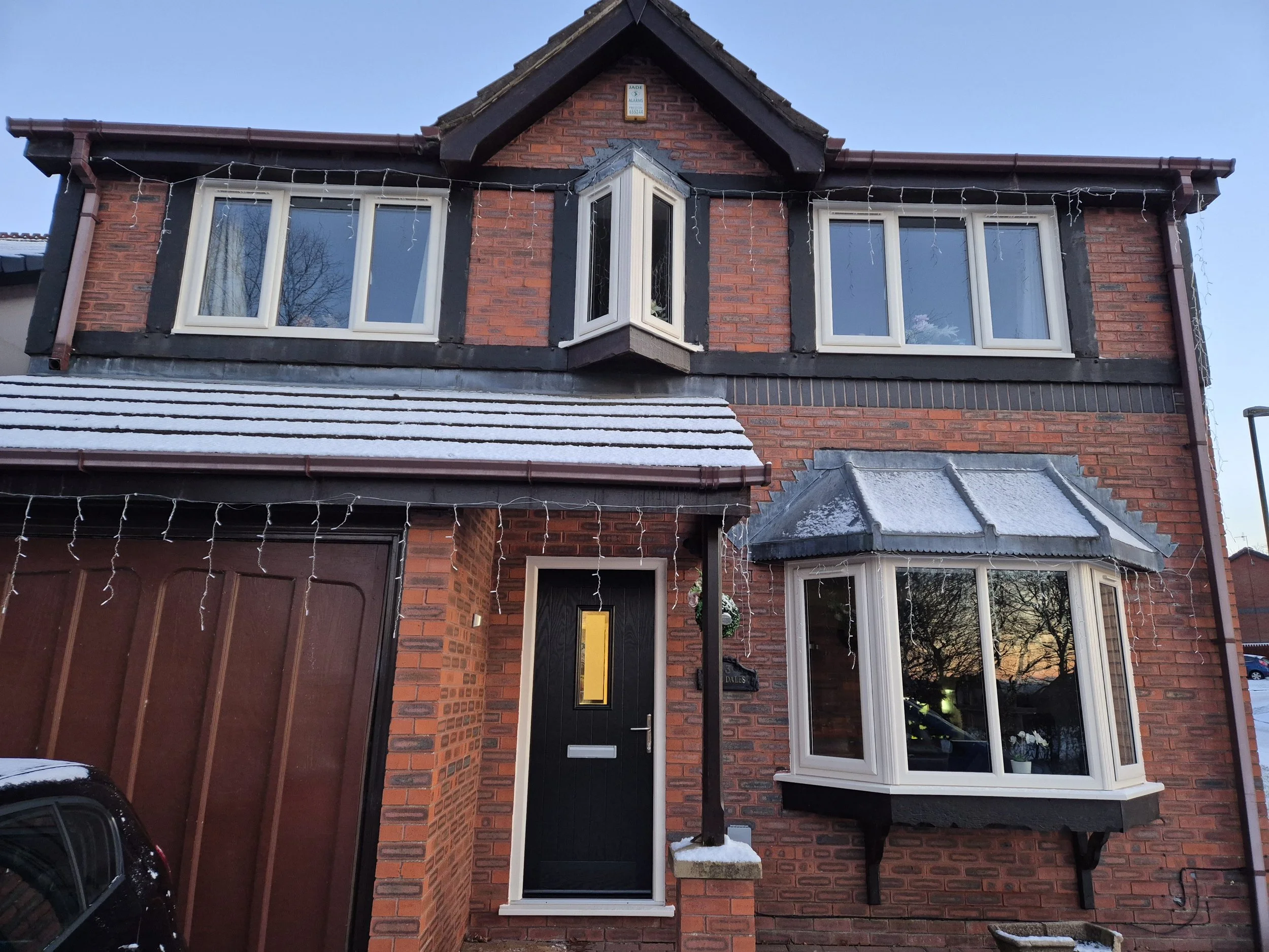 Full house PVC window transformation paired with a striking black composite front door fitted in a contrasting white frame.