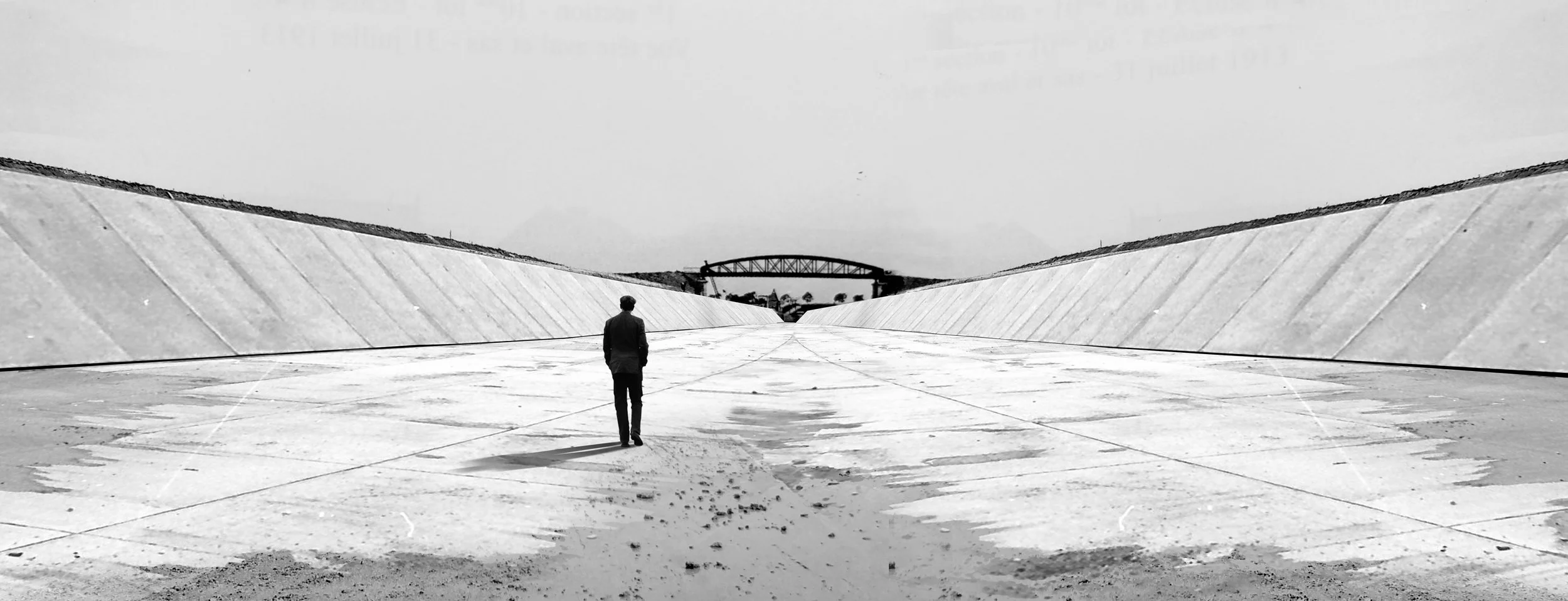 Un homme marche dans un canal asséché.