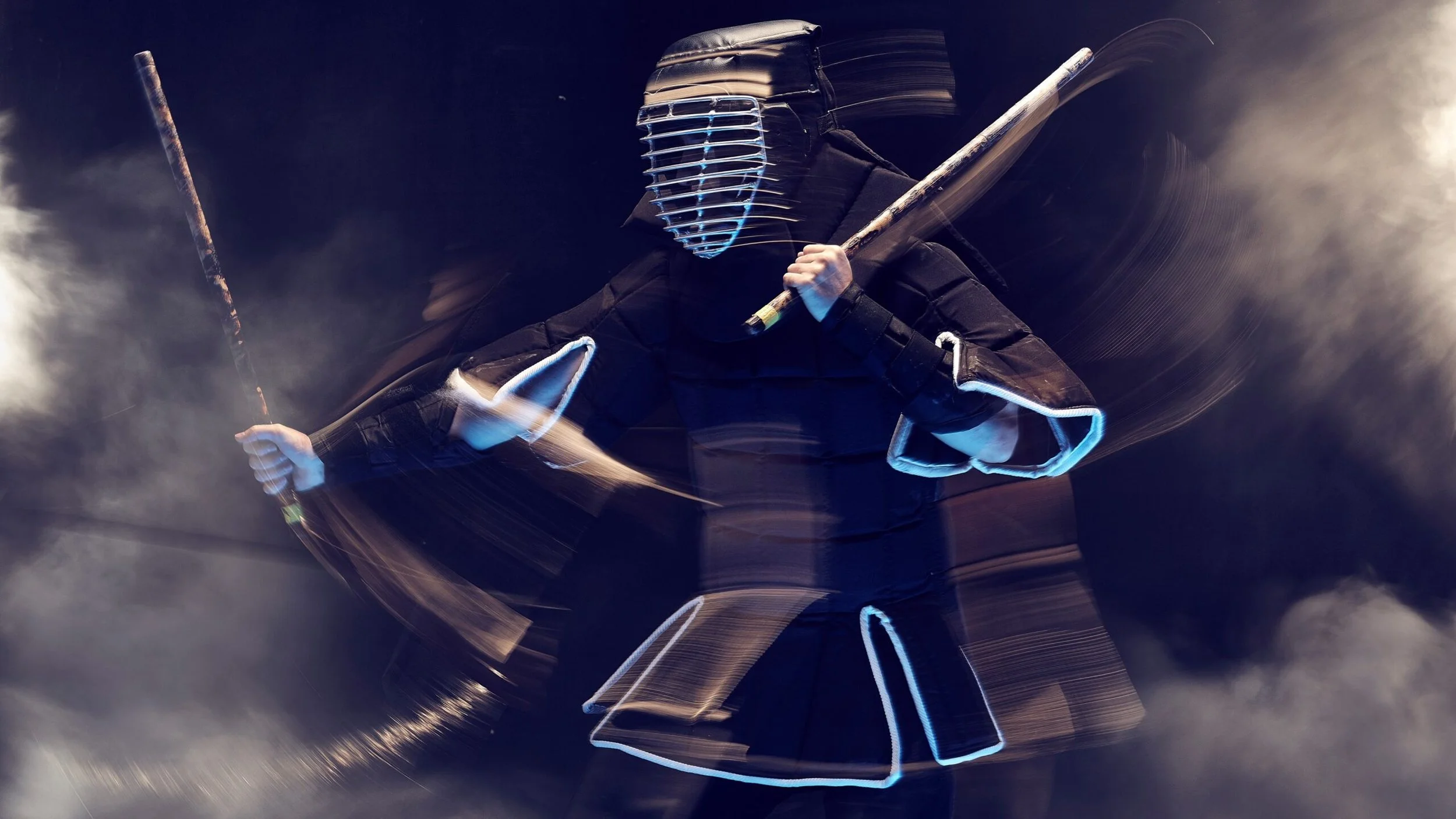 A person dressed in black with a glowing mask and glowing outlines on the clothing, holding two large sticks, surrounded by swirling motion lines and clouds of smoke or mist.