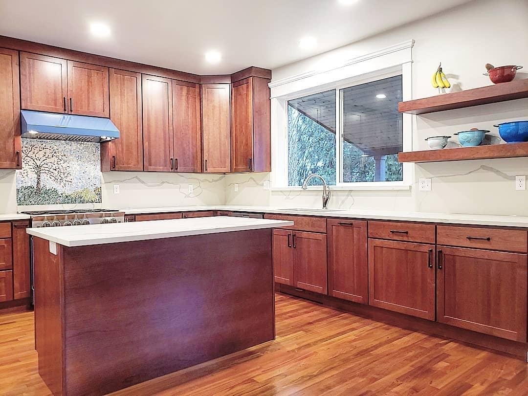 Unique and custom Lake Forest Park kitchen remodel. We custom built a step stool pull-out for the sink, added a Sub Zero mini fridge, a microwave drawer, a custom glass art piece over the 36" gas range, pull-out corner cabinets, lazy susan upper corn