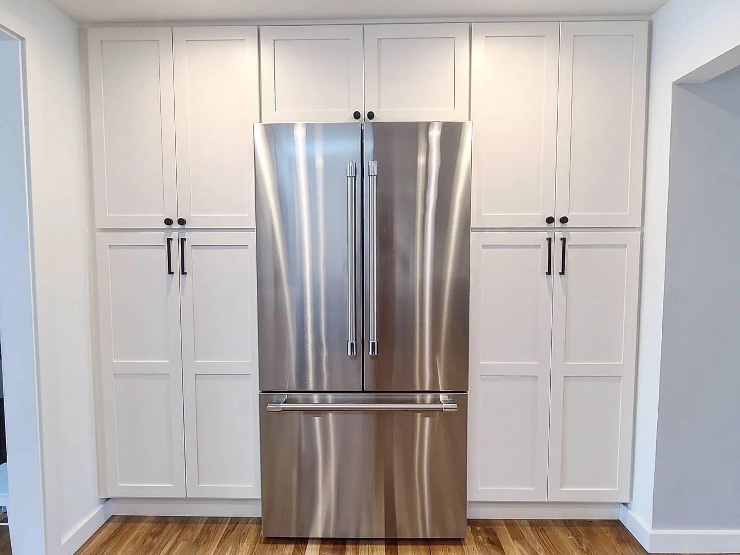 Wedgwood Seattle kitchen remodel with unique blend of both blue and white cabinetry, gorgeous stainless steel appliances, and beautiful waterfall countertop.