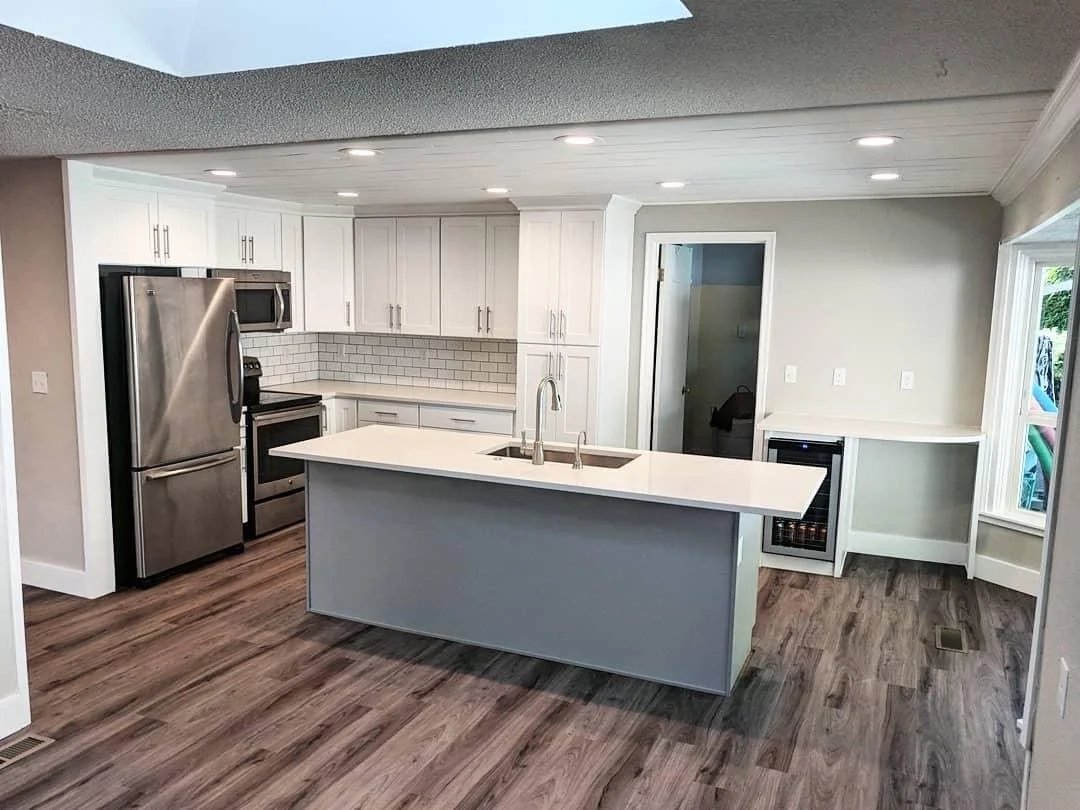 Modern Kingsgate Kitchen remodel opened up with knocked down walls. Shiplapped ceiling, well-placed can lighting, and finishing details include a wine fridge, a work desk, flooring, cabinets, countertops, and much more.